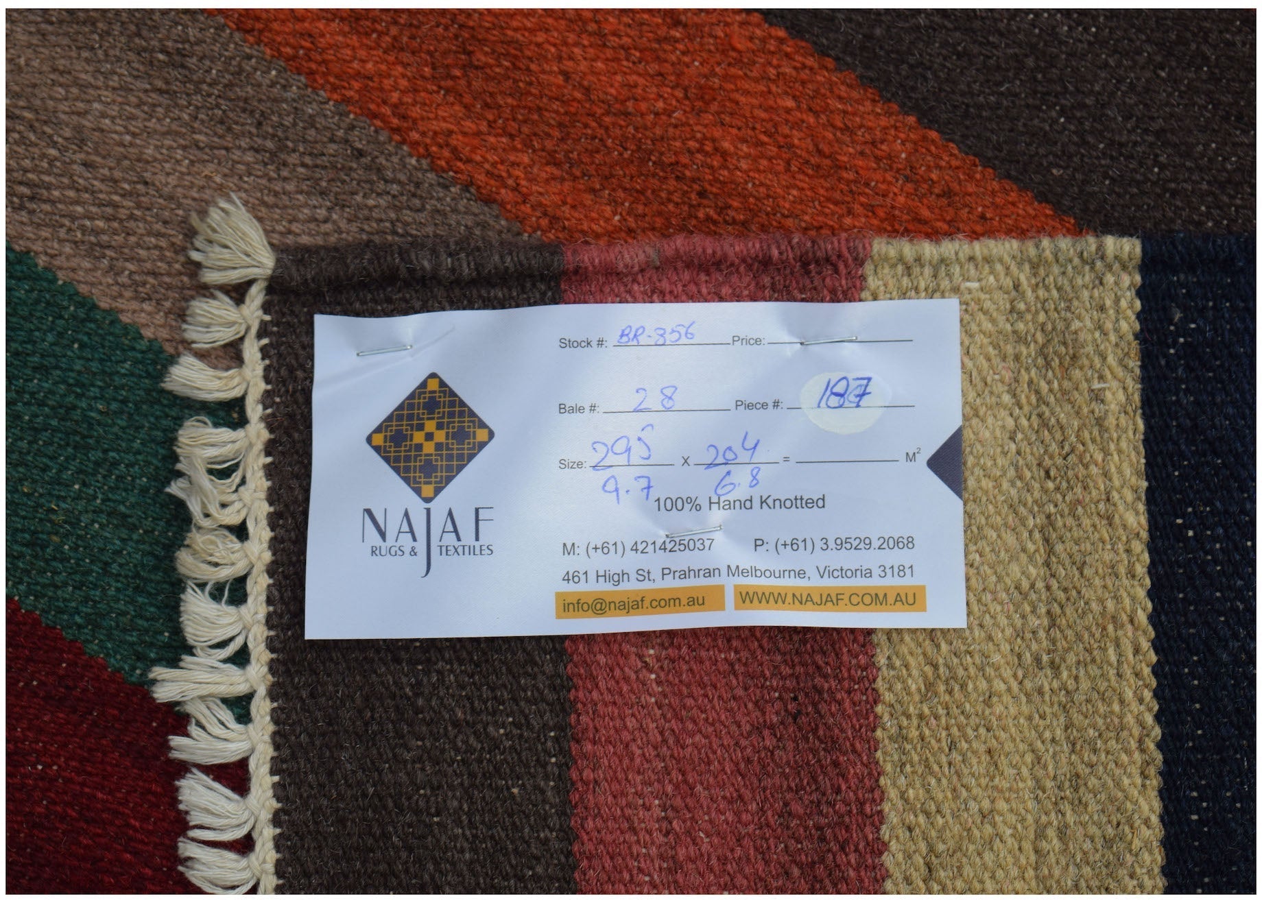 An Afghan Maimana Kilim rug featuring a geometric pattern in rich, warm colors.