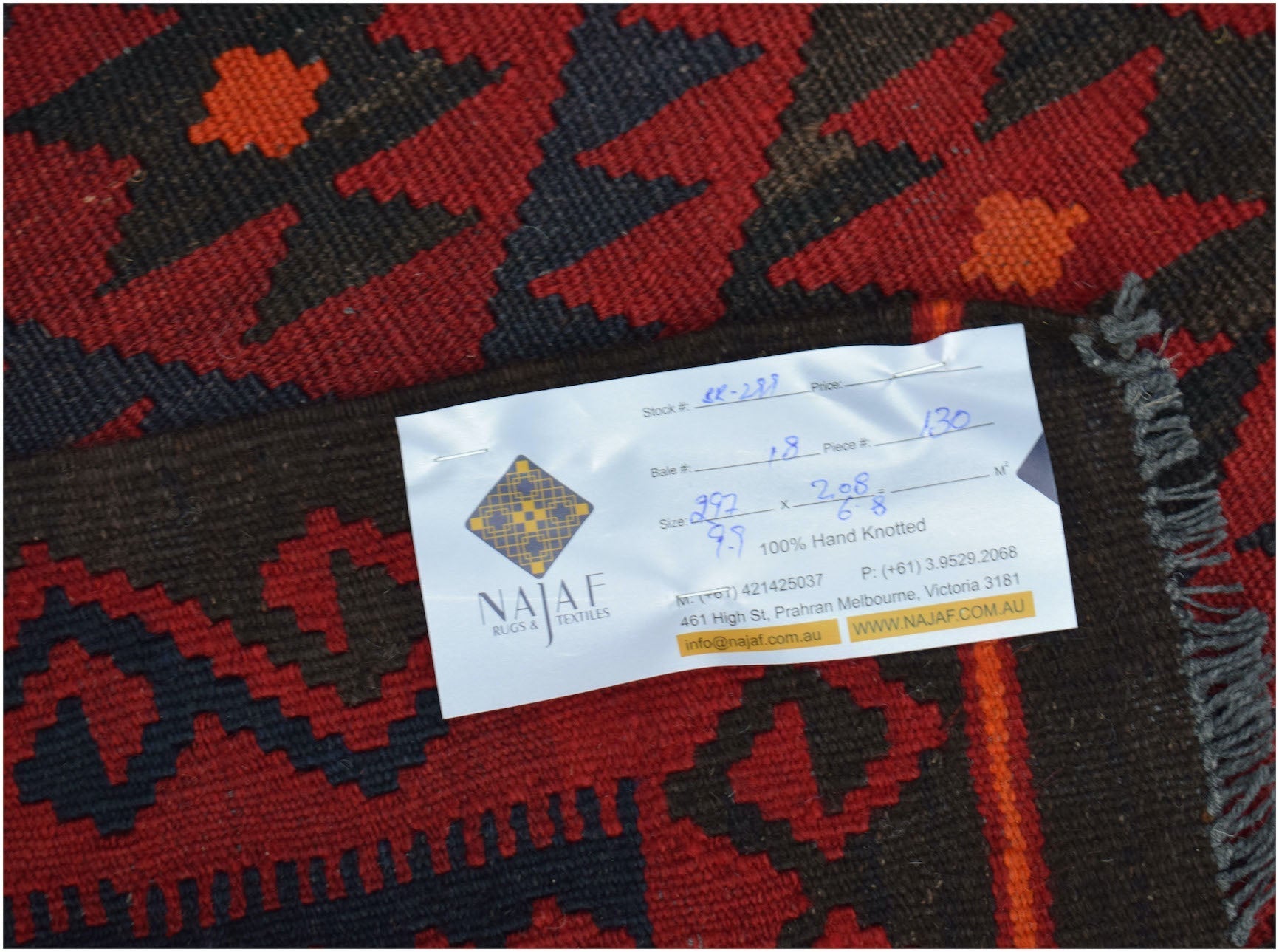 A handwoven Afghan Maimana kilim featuring a geometric pattern in deep red and dark brown tones.