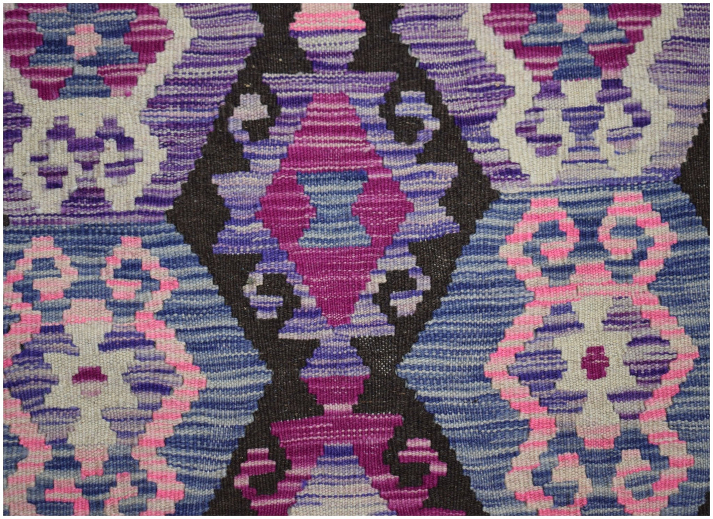 Handwoven Afghan Maimana kilim featuring a geometric pattern in shades of purple, pink, and blue.