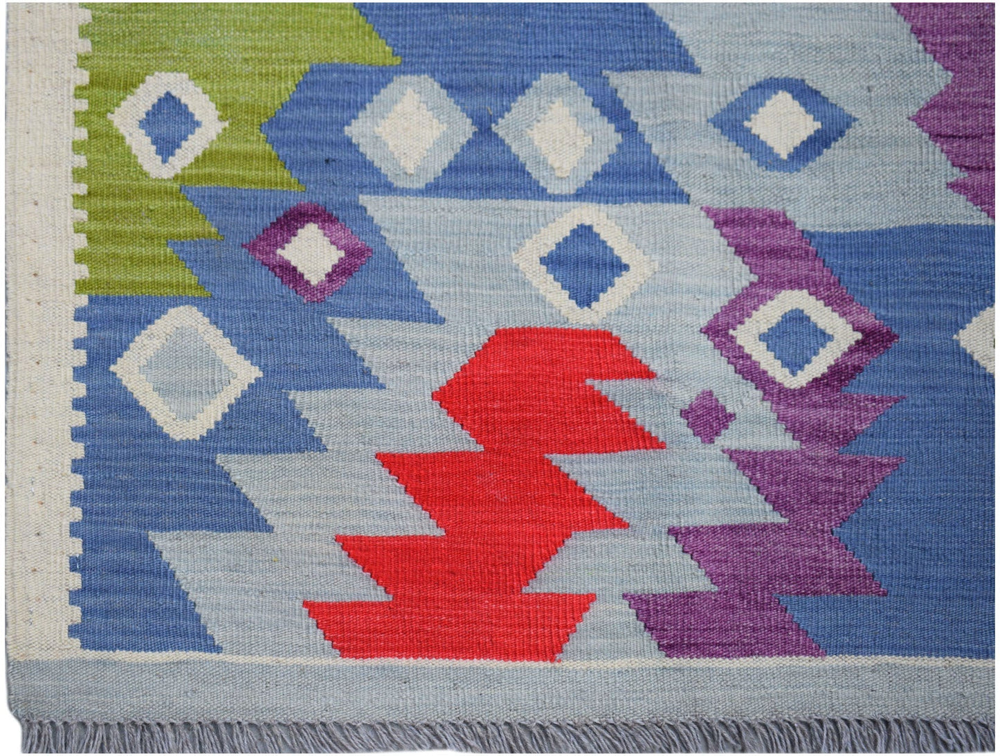 Handwoven Afghan Maimana kilim rug featuring a geometric pattern in blue, red, green, and purple.
