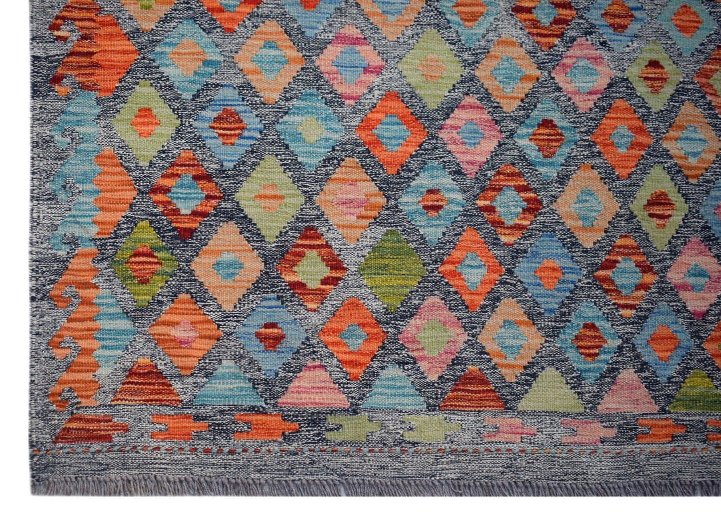 Handwoven Afghan Maimana kilim rug featuring a colorful geometric diamond pattern on a dark base.