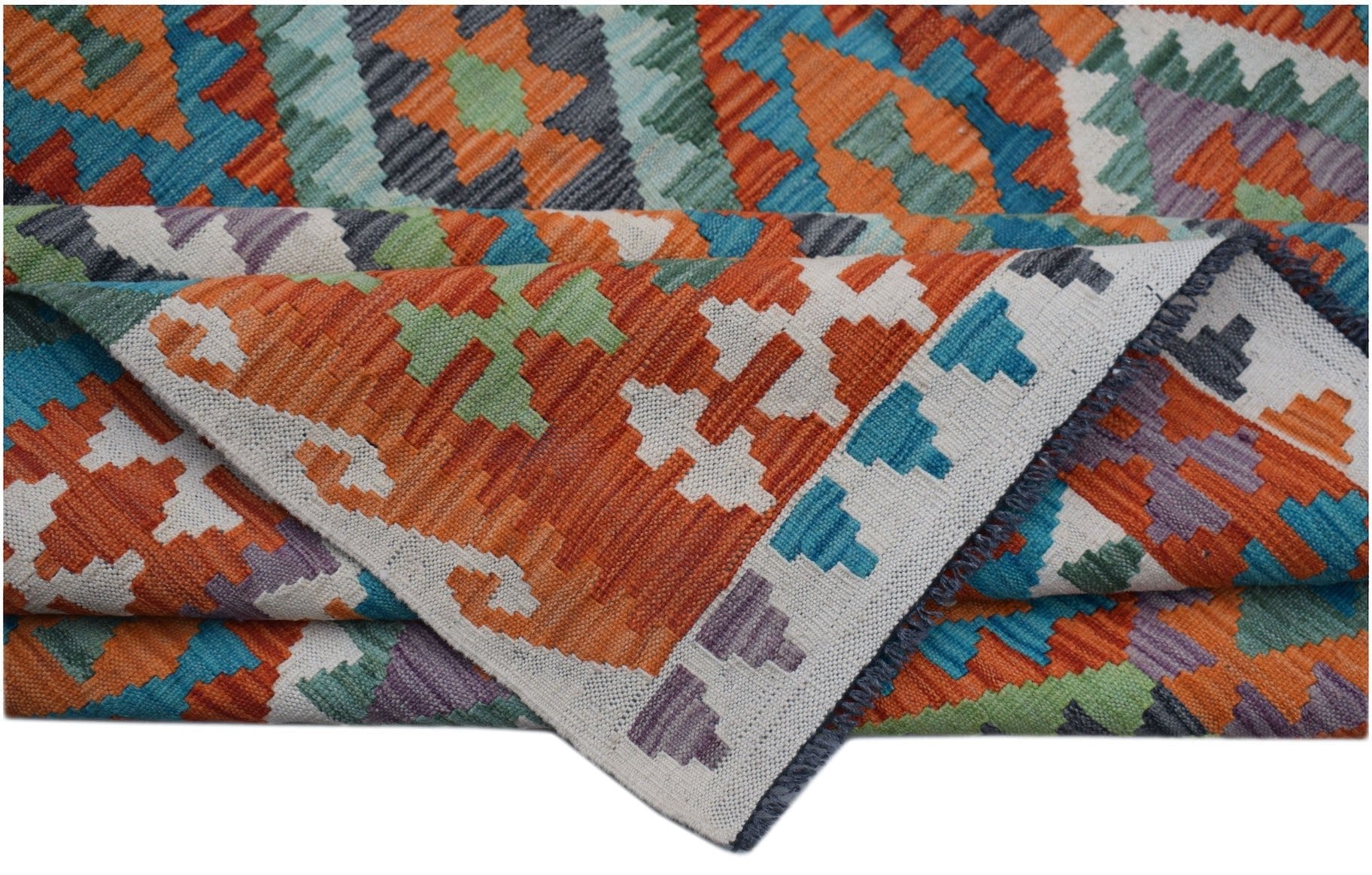 A handwoven Afghan Maimana kilim rug featuring a vibrant geometric pattern in wool.