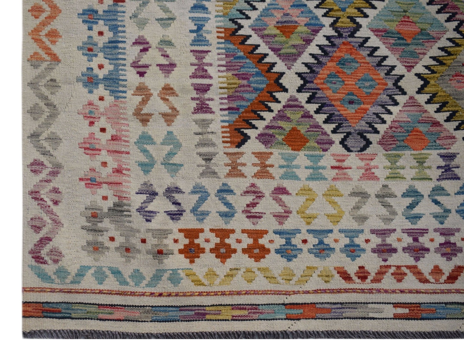 Handwoven Afghan Maimana kilim rug featuring a colorful geometric pattern on a cream background.
