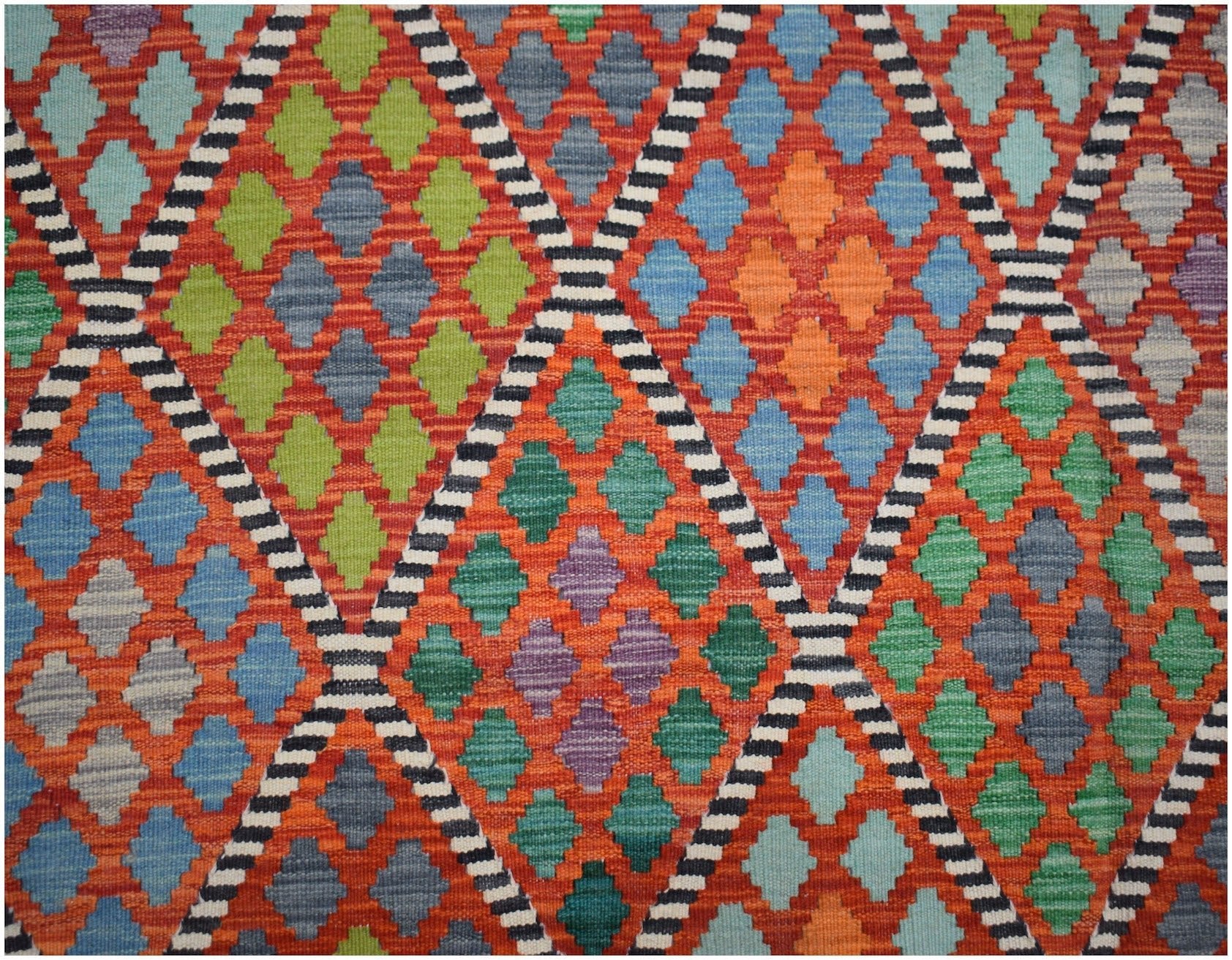 Handwoven Afghan Maimana kilim featuring a vibrant geometric diamond pattern in wool.