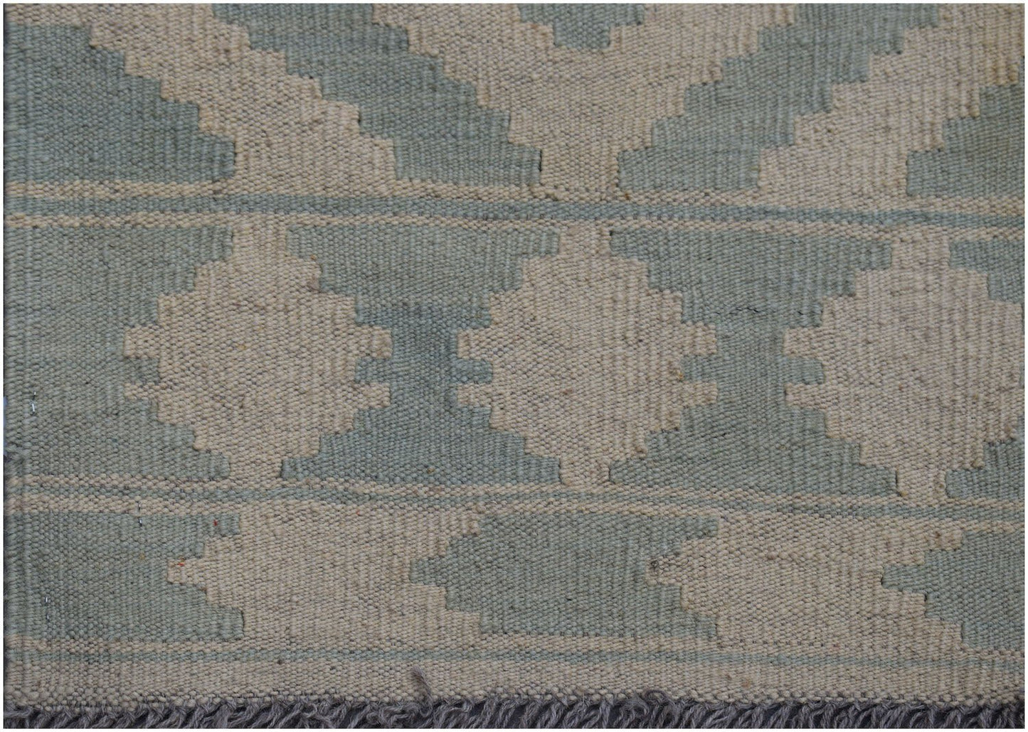 Handwoven Afghan Maimana kilim rug featuring a geometric pattern in sage green and cream wool.