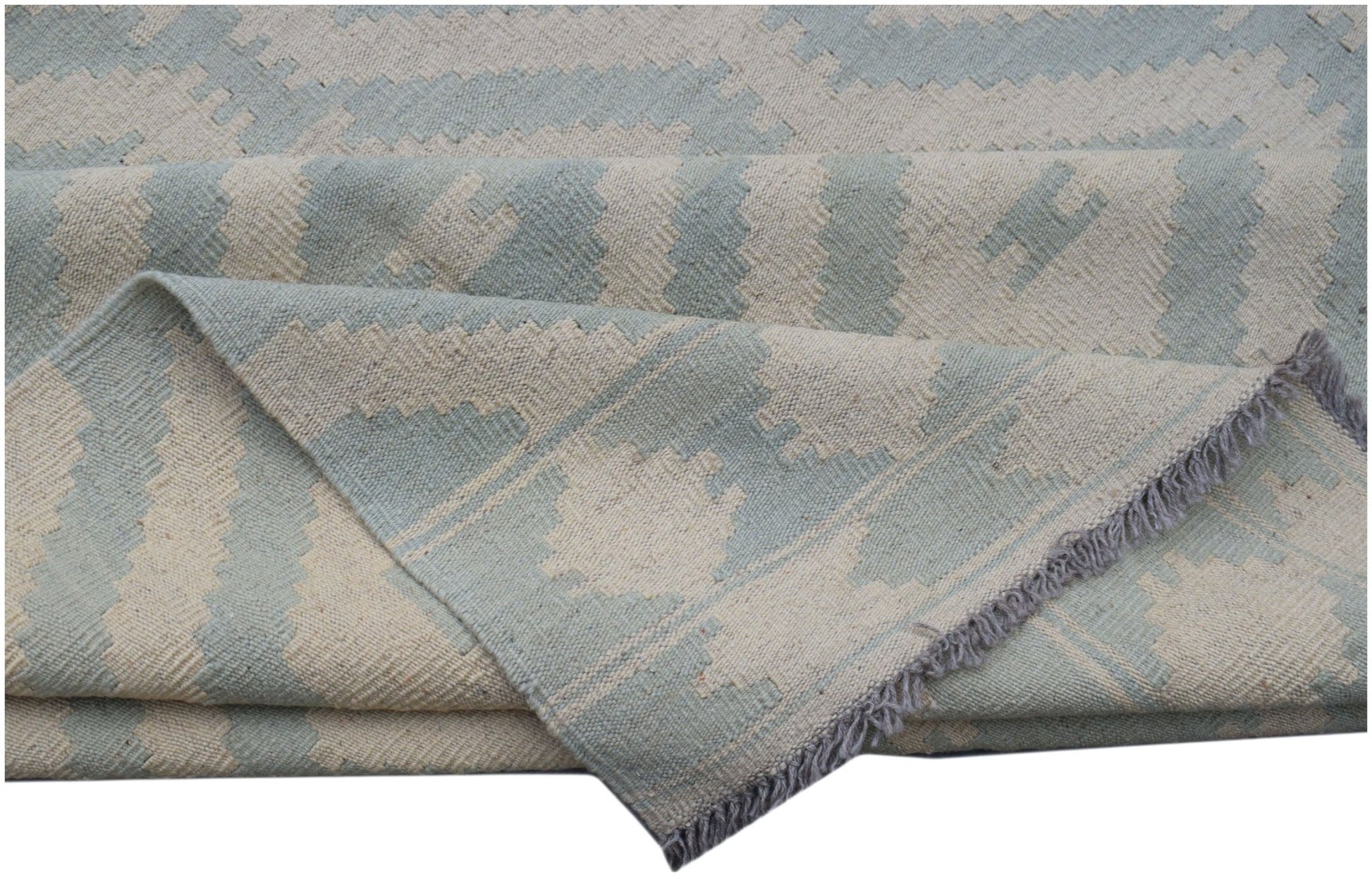 A handmade Afghan Maimana kilim rug featuring a geometric pattern in light blue and cream wool.