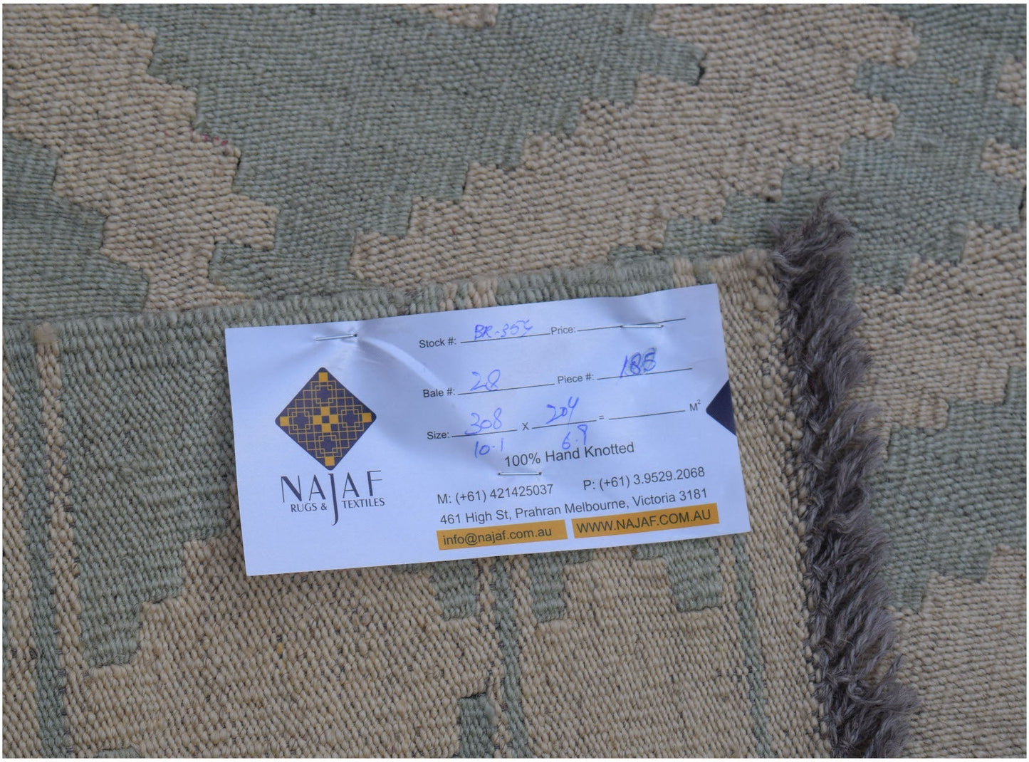 A flatwoven Afghan Maimana kilim rug featuring a geometric pattern in muted green and beige tones.