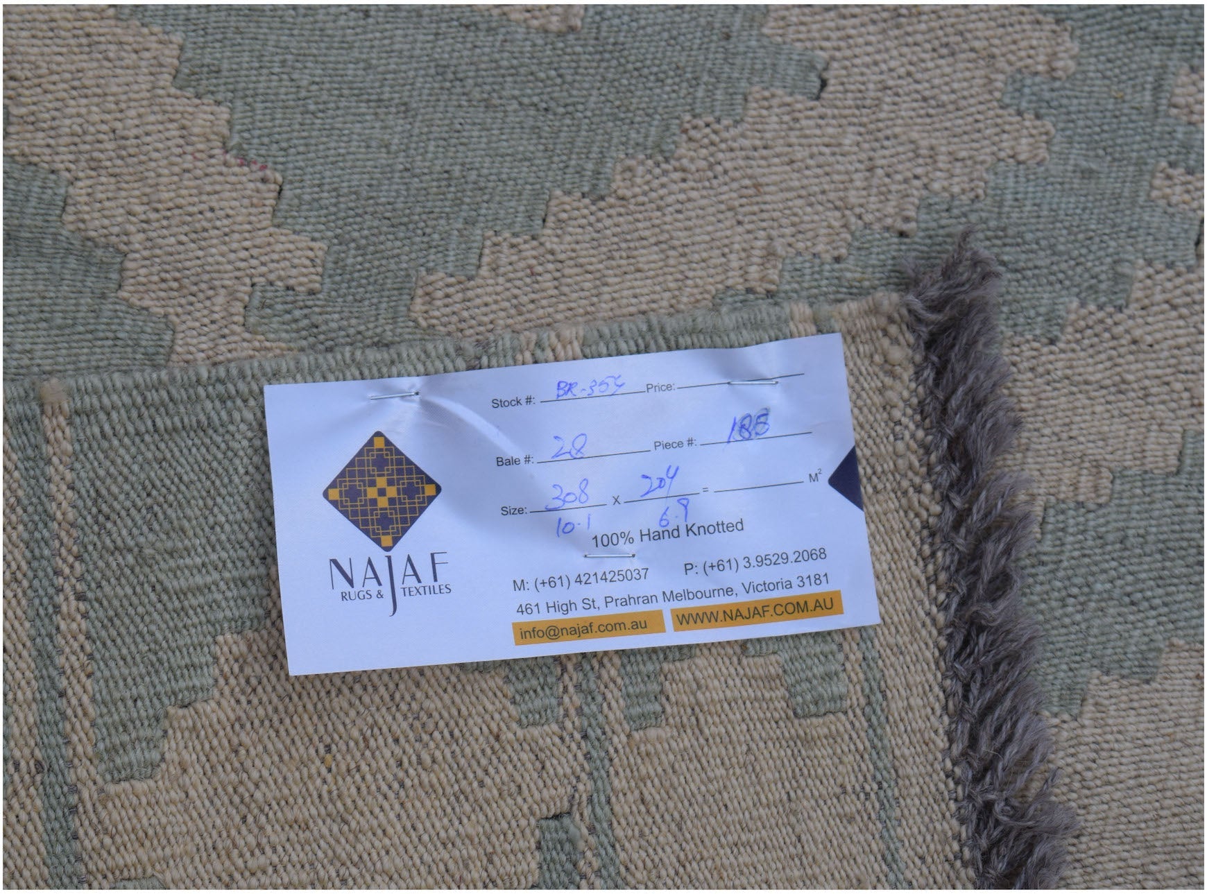 A flatwoven Afghan Maimana kilim rug featuring a geometric pattern in muted green and beige tones.