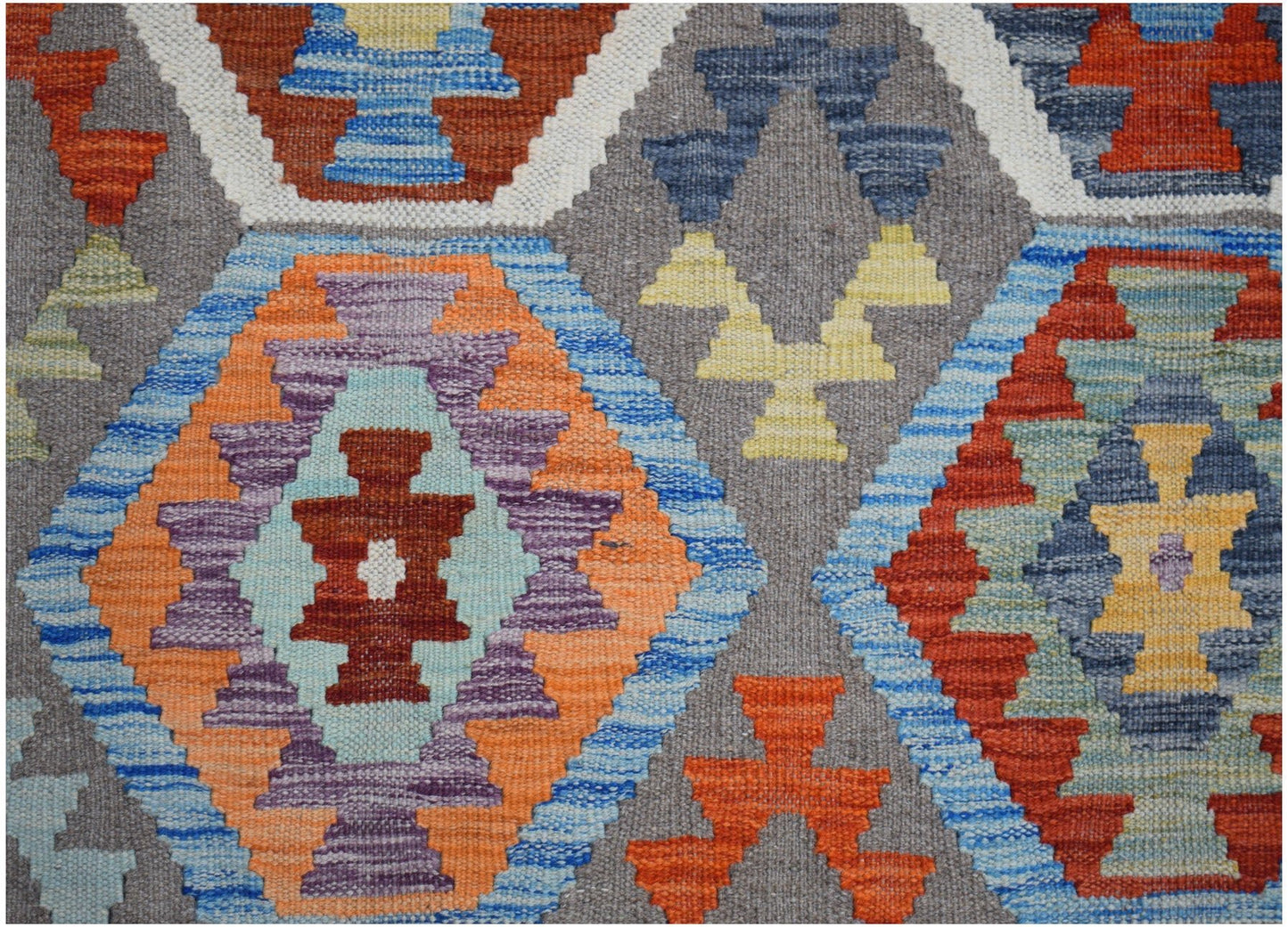 Handwoven Afghan Maimana kilim rug featuring a geometric pattern in vibrant multicolored diamonds.