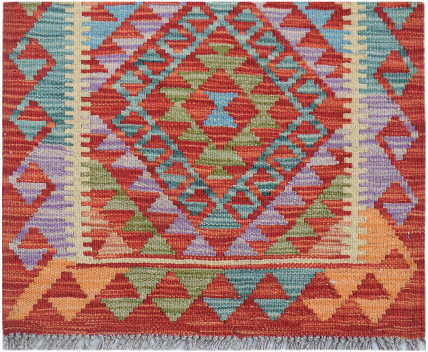 Handwoven Afghan Maimana wool runner featuring a geometric diamond pattern in vibrant colors.