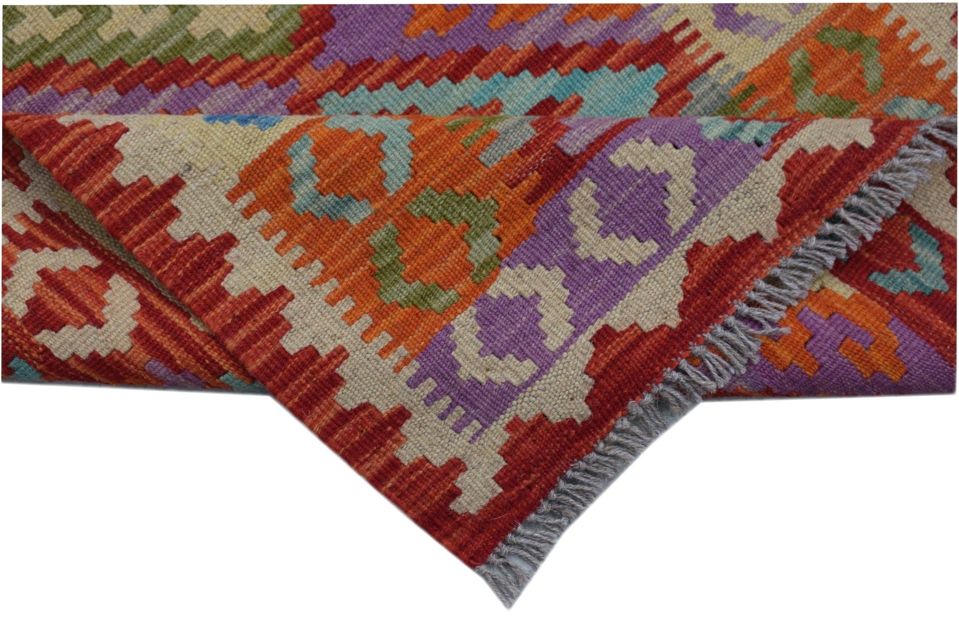 A handmade Afghan Maimana wool kilim runner featuring vibrant geometric patterns and fringe edges.