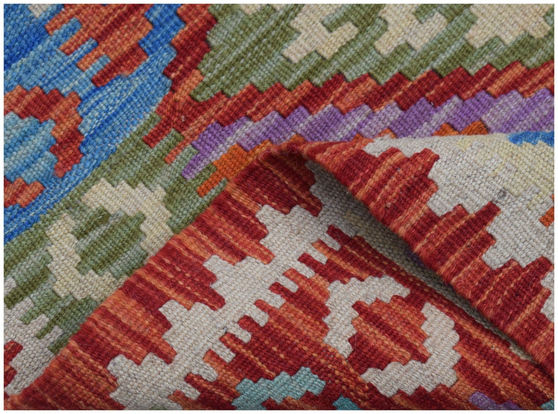 A handwoven Afghan Maimana kilim runner featuring a vibrant geometric pattern in wool.