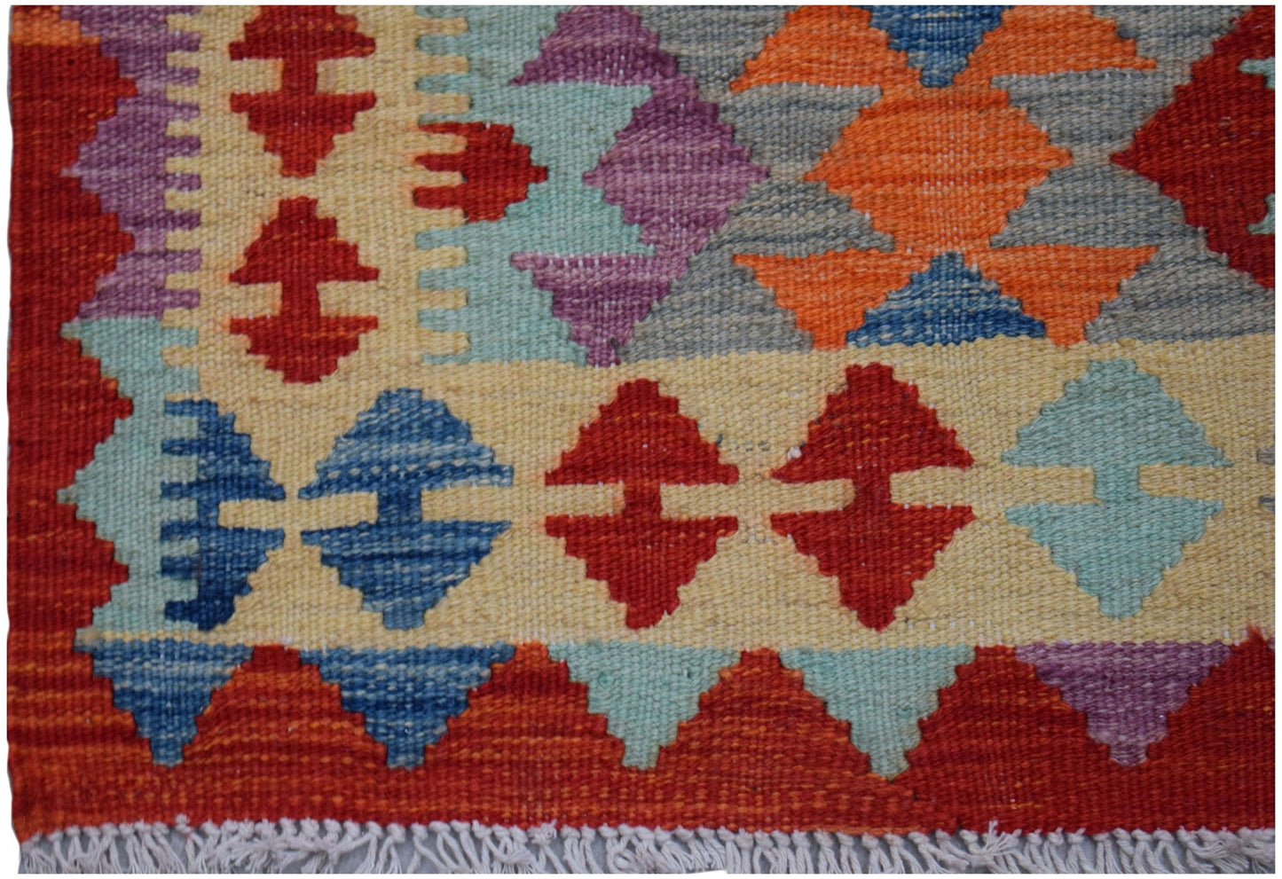 Handwoven Afghan Maimana kilim runner featuring a colorful geometric pattern on a wool base.