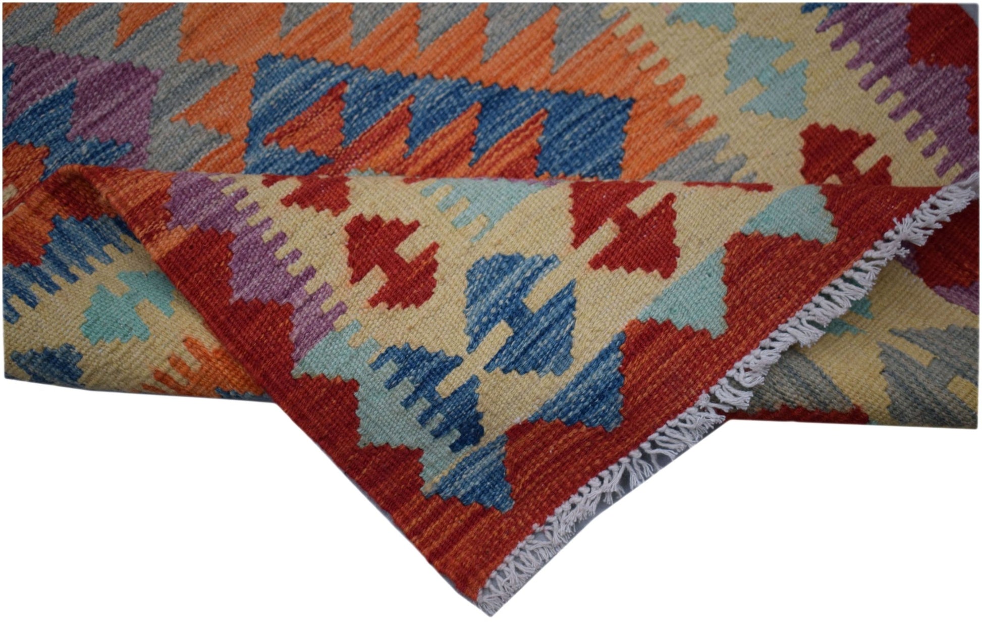 A handwoven Afghan Maimana kilim runner featuring a geometric pattern in vibrant wool colors.