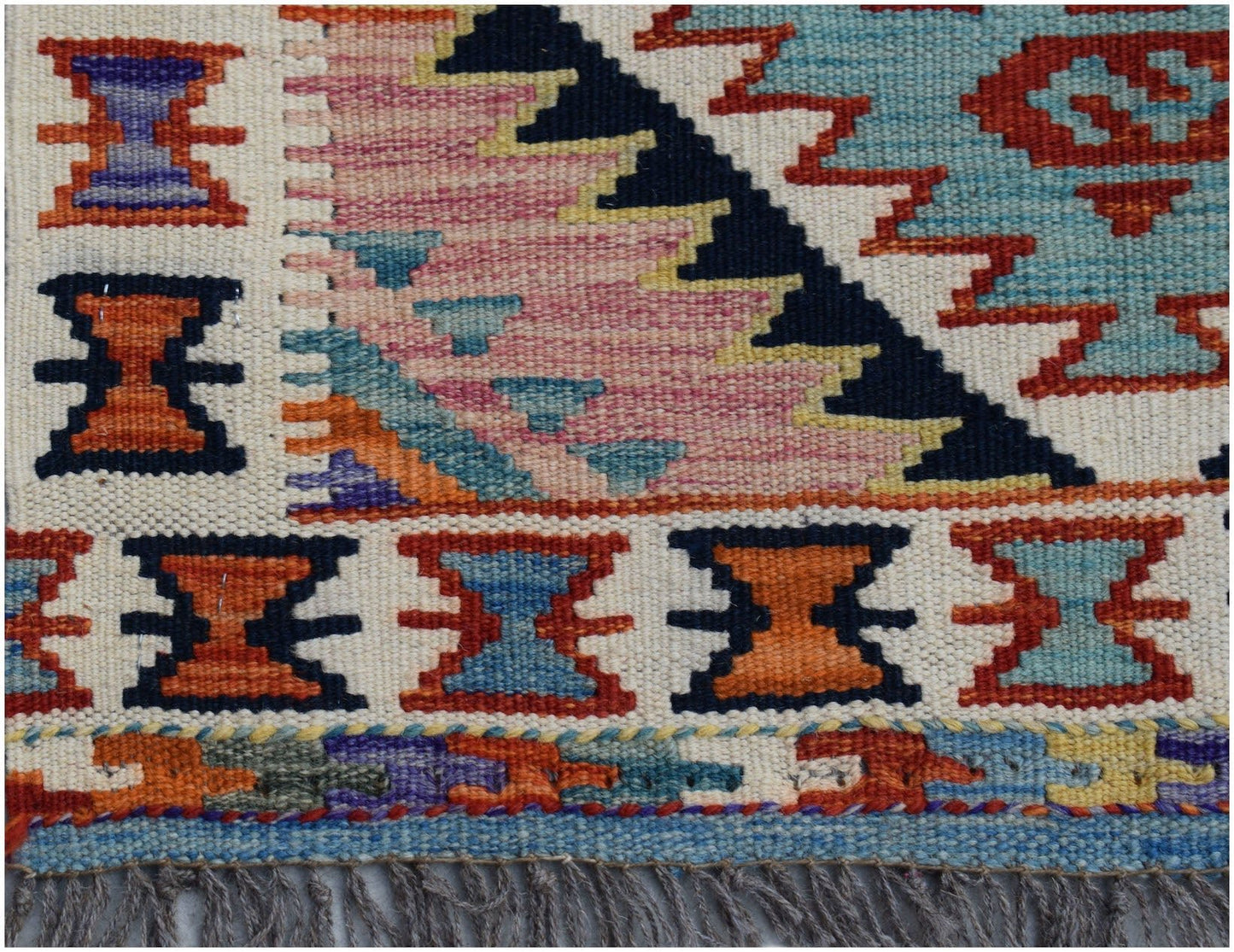 Handwoven Afghan Maimana kilim runner featuring geometric patterns in vibrant wool colors.