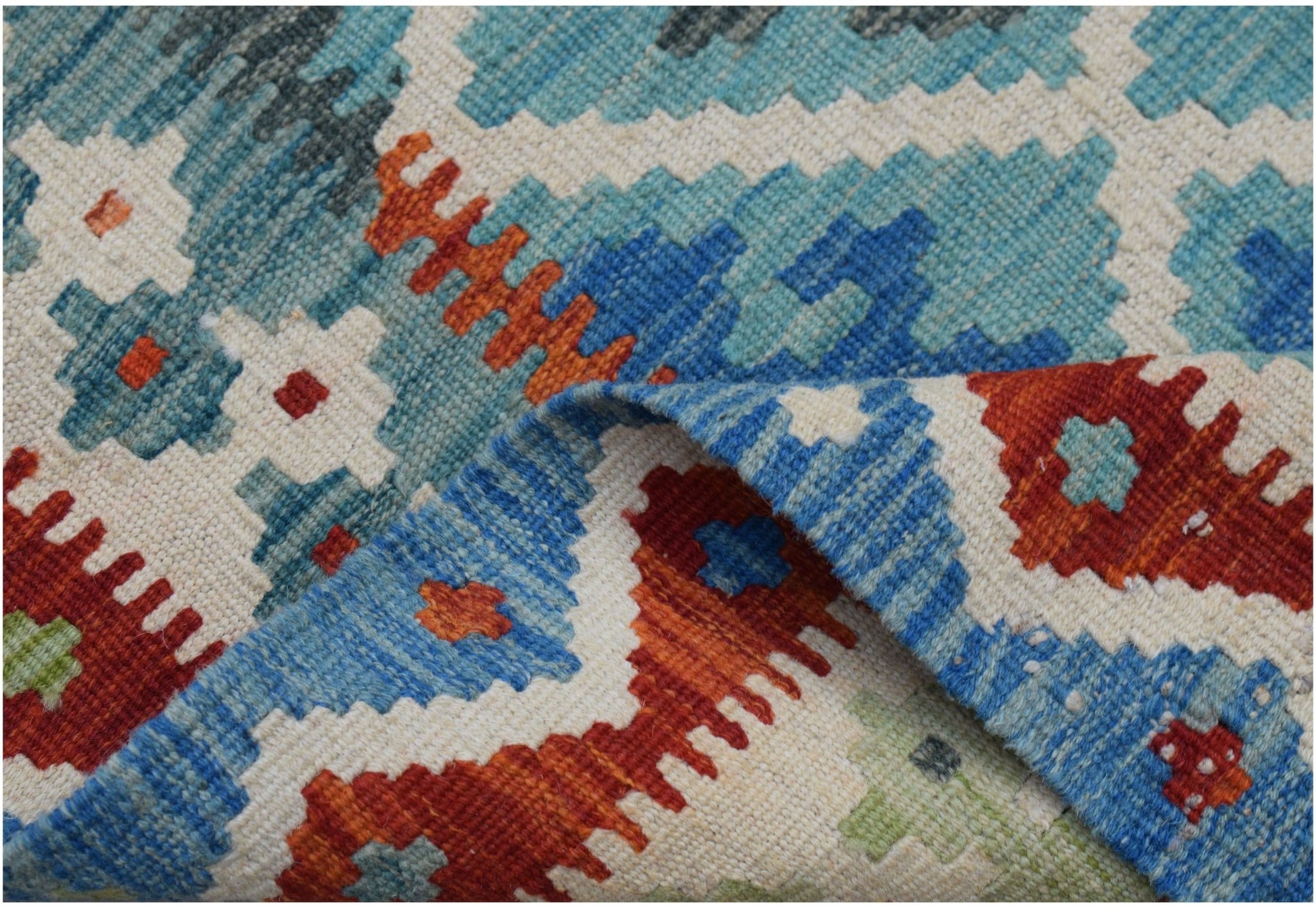 A handmade Afghan Maimana kilim runner featuring a geometric pattern in blue, red, and cream wool.