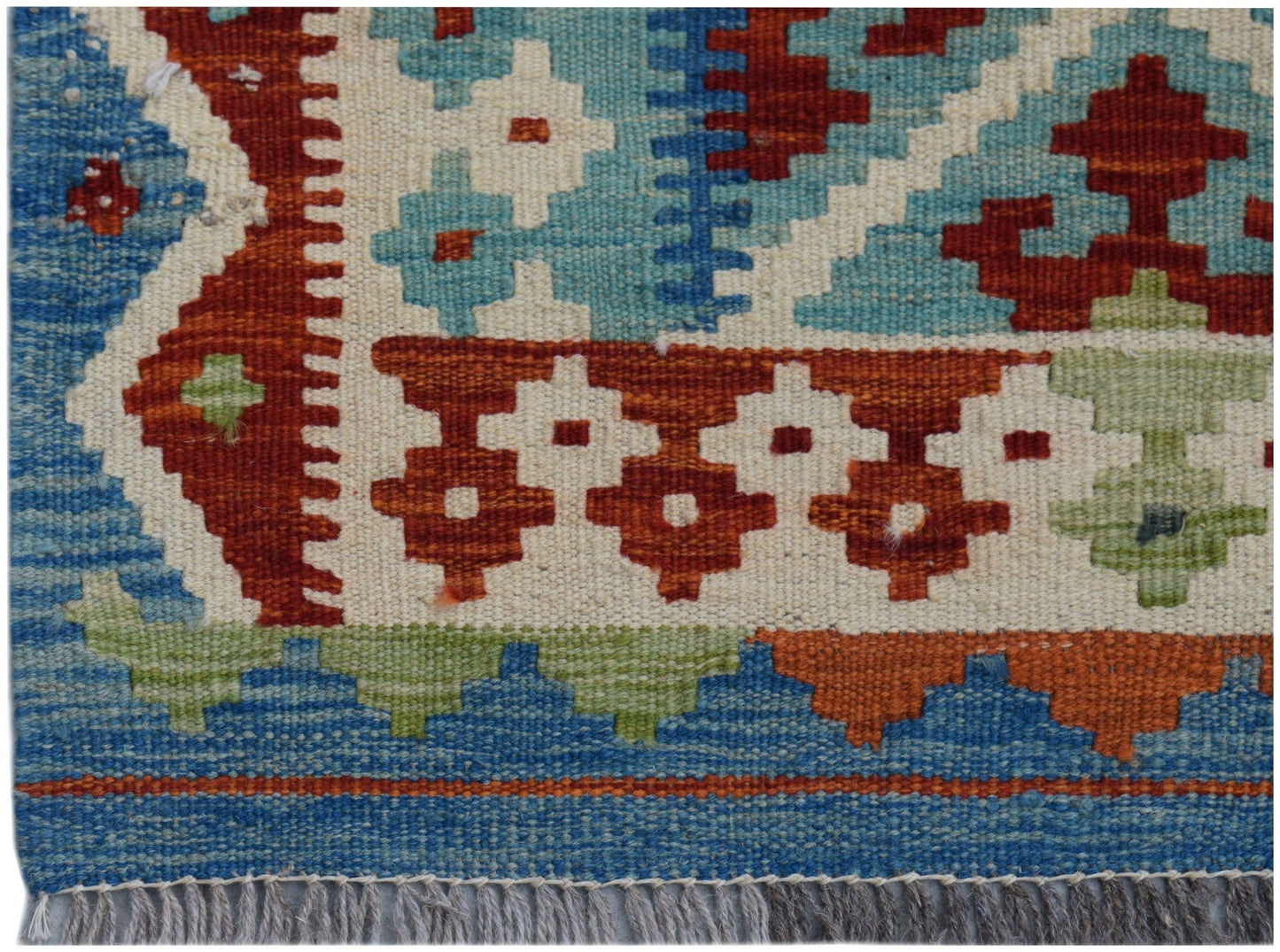 Handwoven Afghan Maimana kilim runner featuring geometric patterns in blue, red, and cream wool.