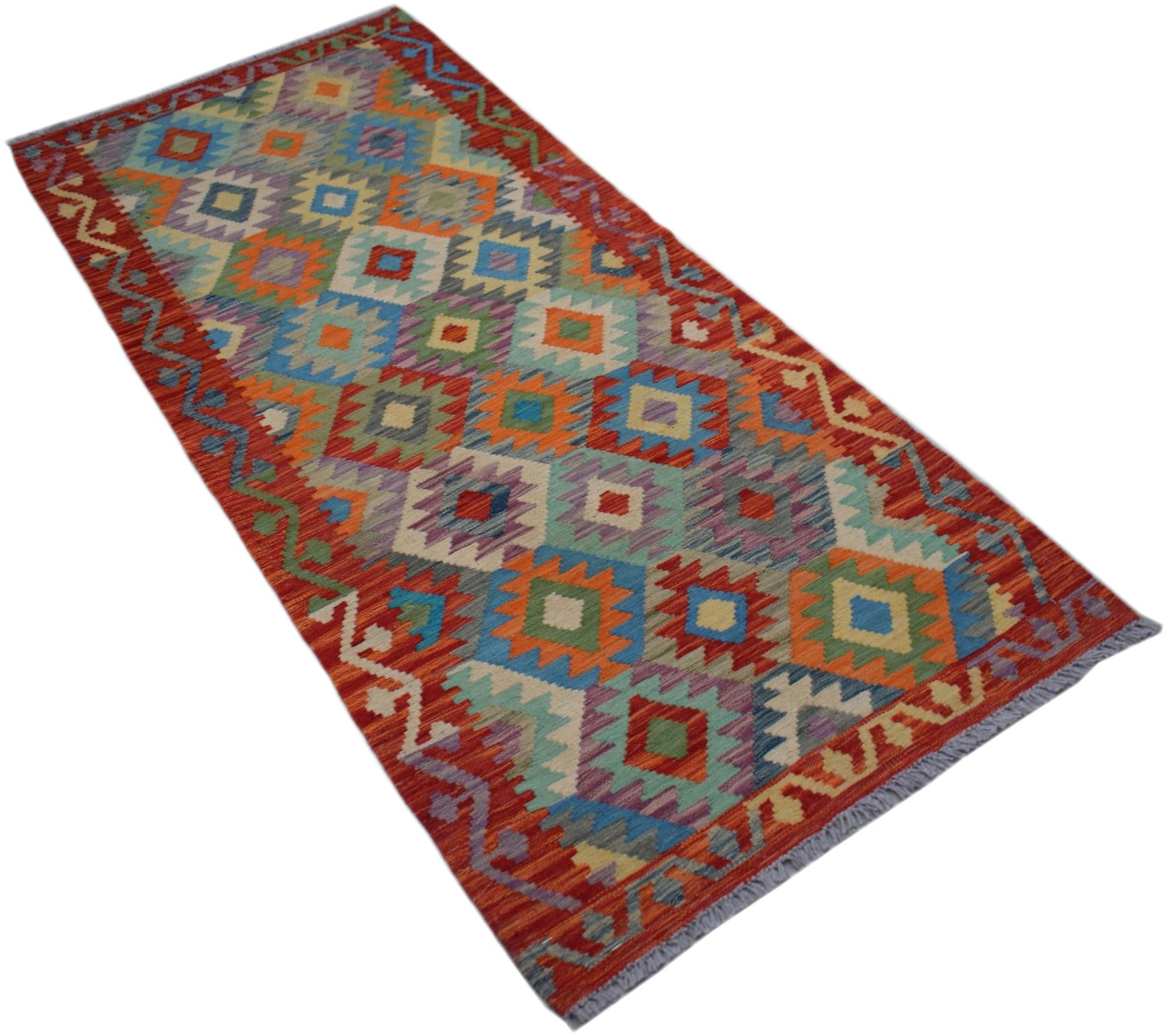 A handmade Afghan Maimana wool runner rug featuring a colorful geometric diamond pattern.