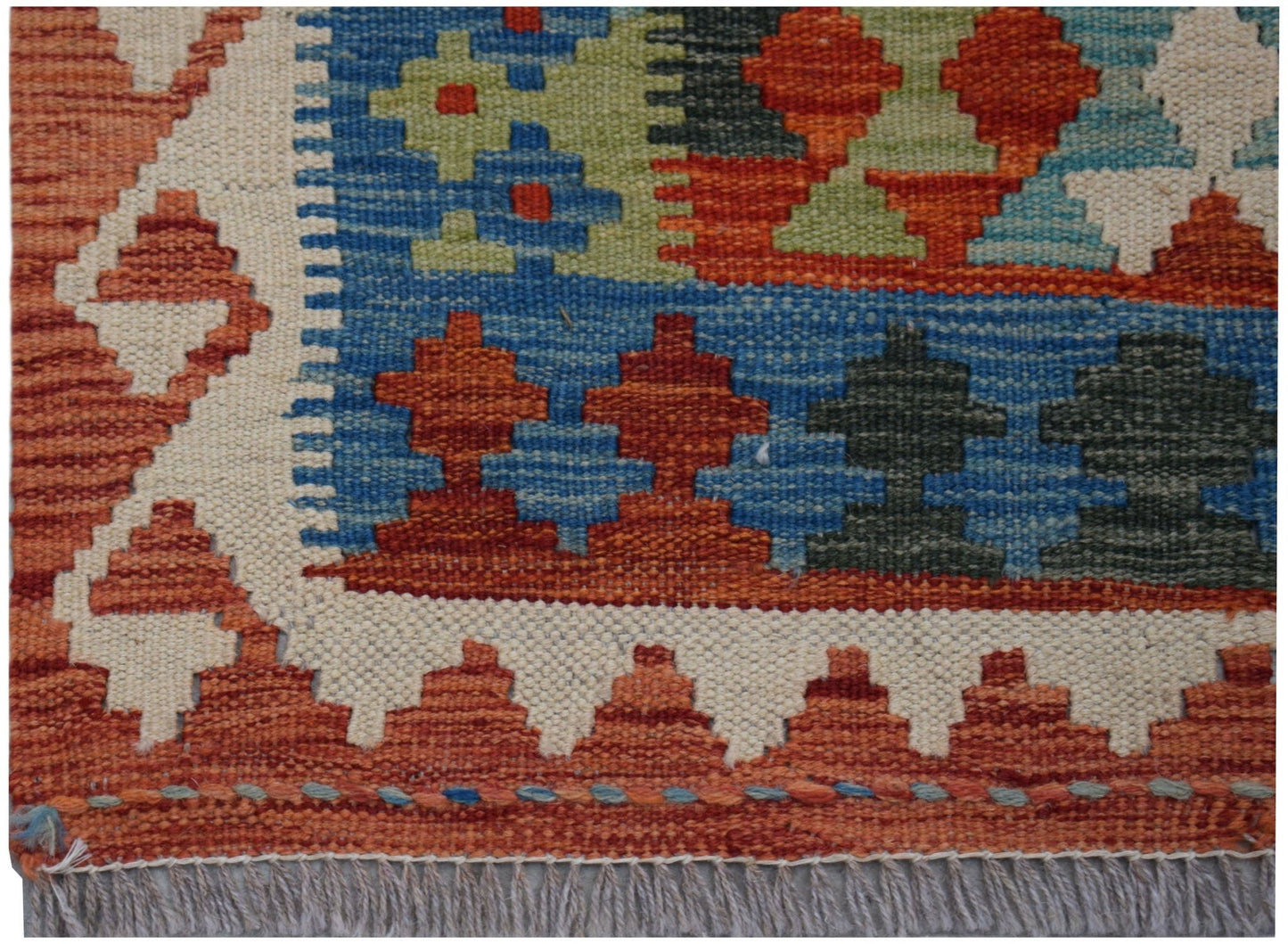 Handwoven Afghan Maimana kilim runner featuring geometric patterns in red, blue, and green wool.