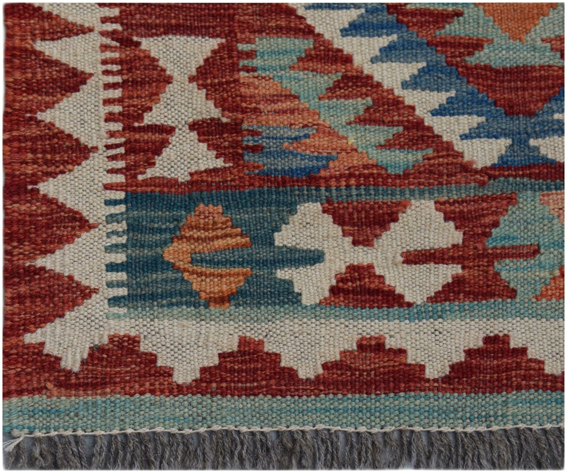 A handmade Afghan Maimana wool kilim runner featuring geometric patterns in red, blue, and cream.