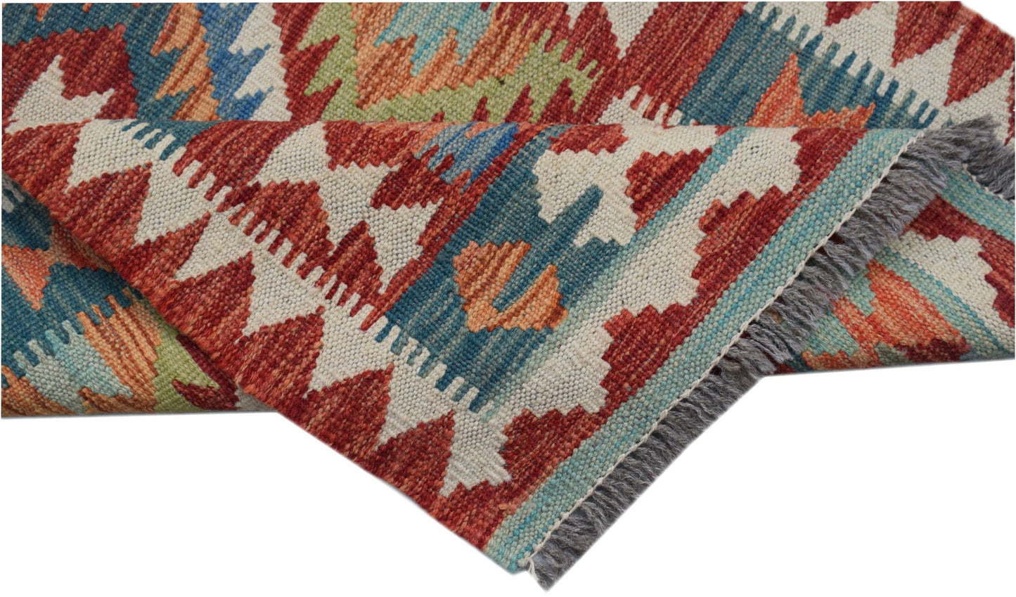 A handwoven Afghan Maimana wool kilim runner featuring a geometric pattern in red, blue, and green.