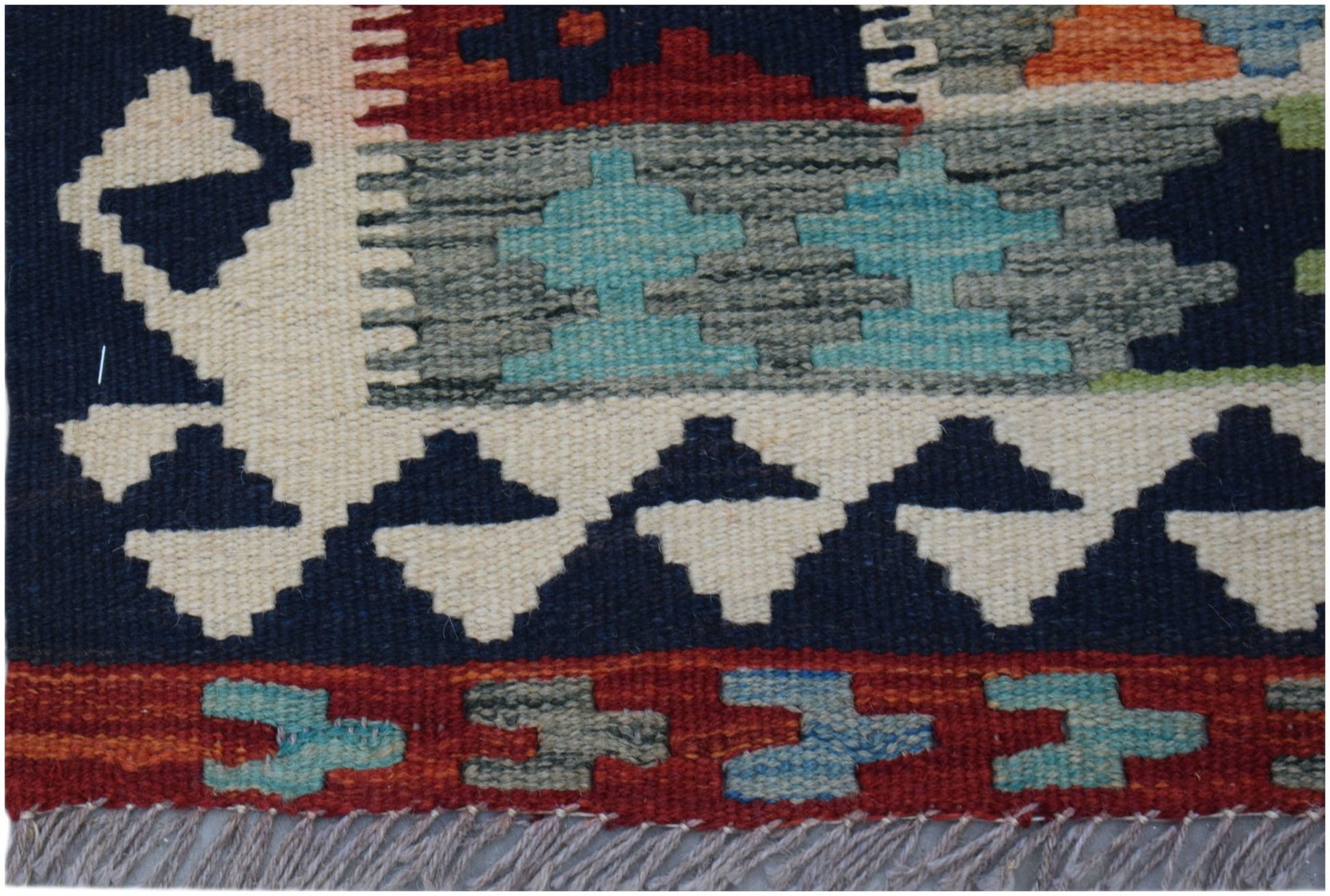 Handwoven Afghan Maimana wool kilim runner featuring geometric patterns in red, blue, and cream.