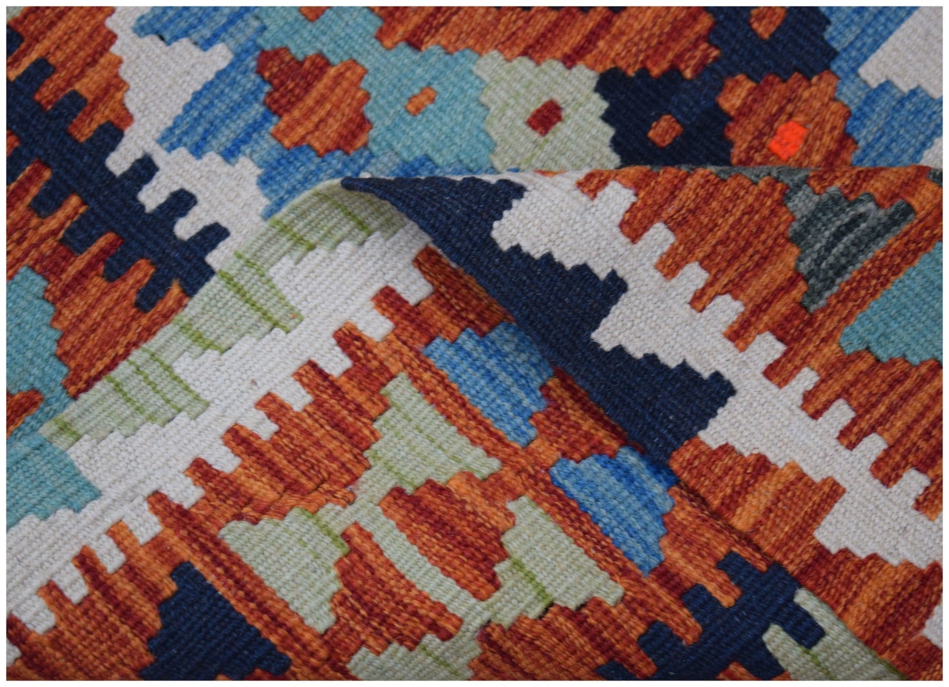 A handwoven wool kilim runner featuring a geometric pattern in orange, blue, and cream tones.