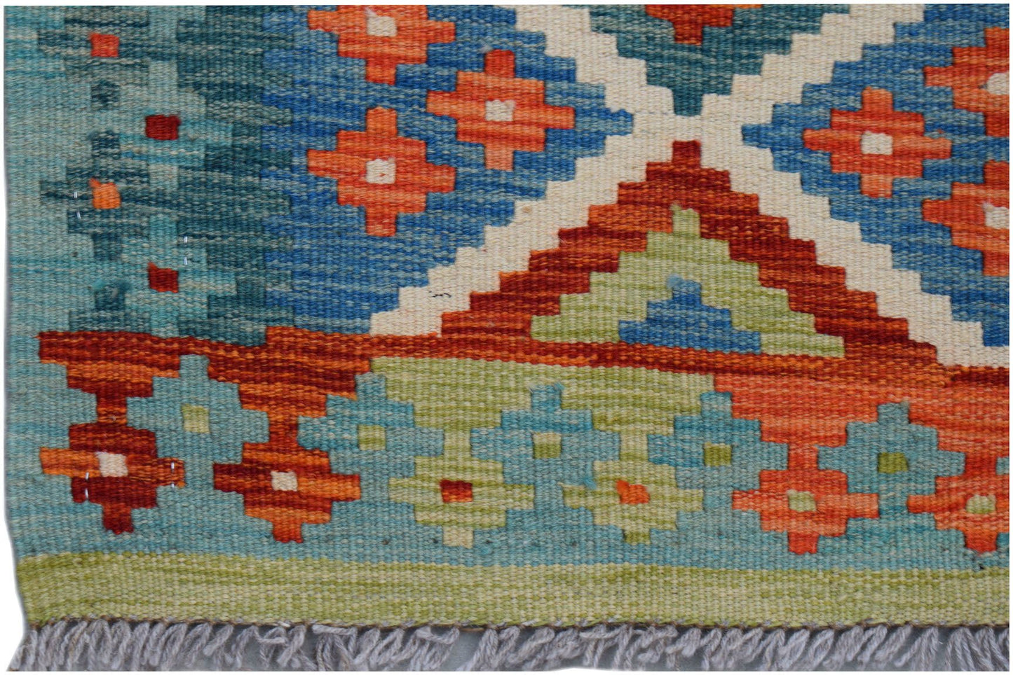 Handwoven Afghan Maimana wool kilim runner featuring a geometric pattern in blue, orange, and green.