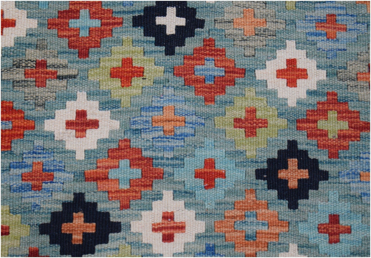 Handwoven wool kilim runner featuring a geometric pattern of colorful crosses on a blue background.