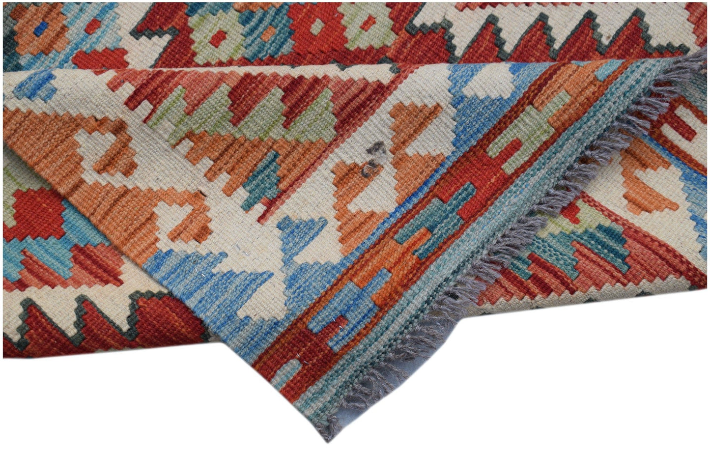 Handwoven Afghan Maimana kilim runner featuring a geometric pattern in red, blue, and orange wool.