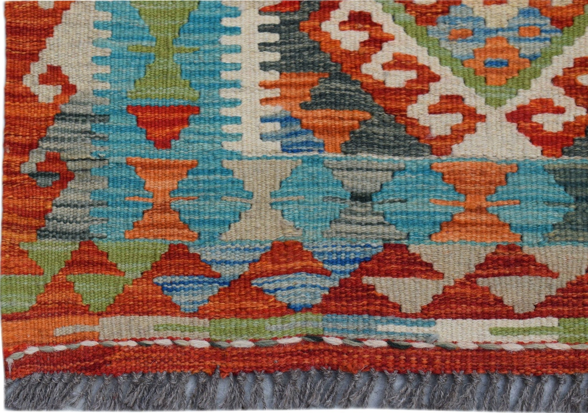 A handwoven Afghan Maimana kilim runner featuring a vibrant geometric pattern in wool.
