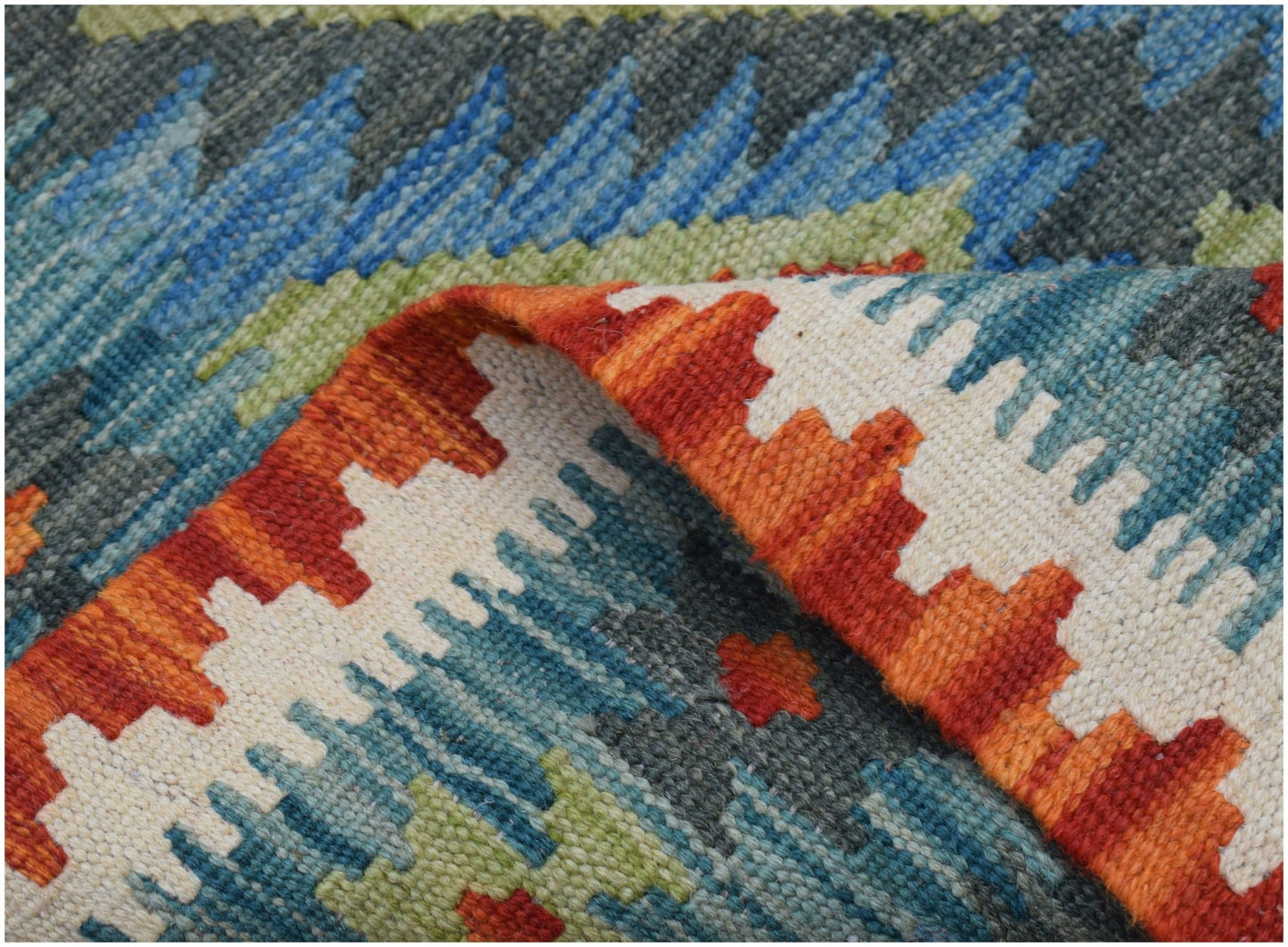 A handwoven Afghan Maimana kilim runner featuring a geometric pattern in orange, blue, and green.