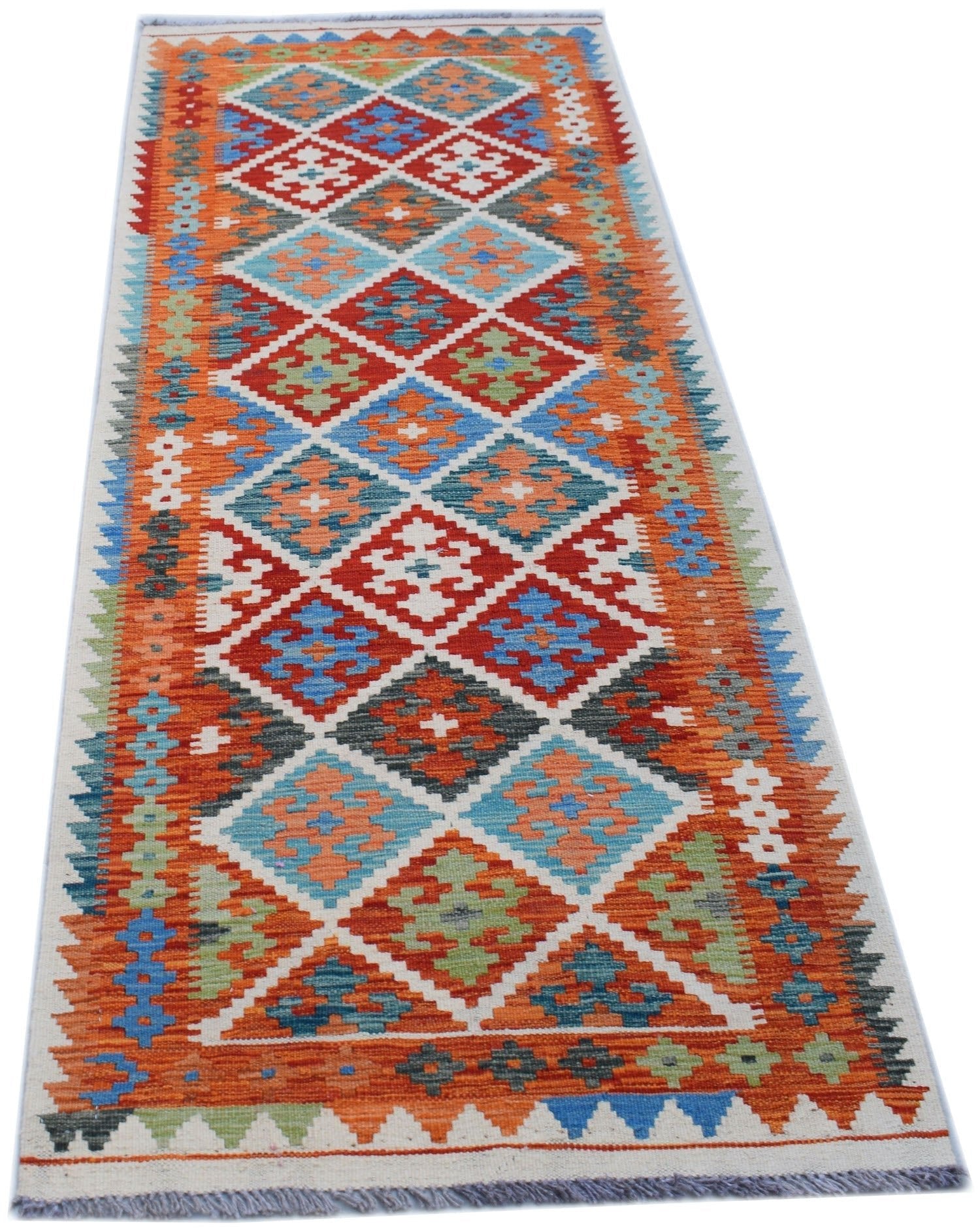 A handmade Afghan Maimana wool runner rug featuring a vibrant geometric diamond pattern.