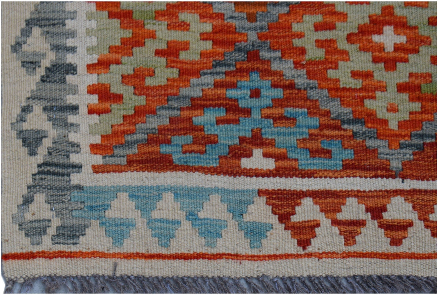 A handmade Afghan Maimana kilim runner featuring geometric patterns in orange, blue, and grey.