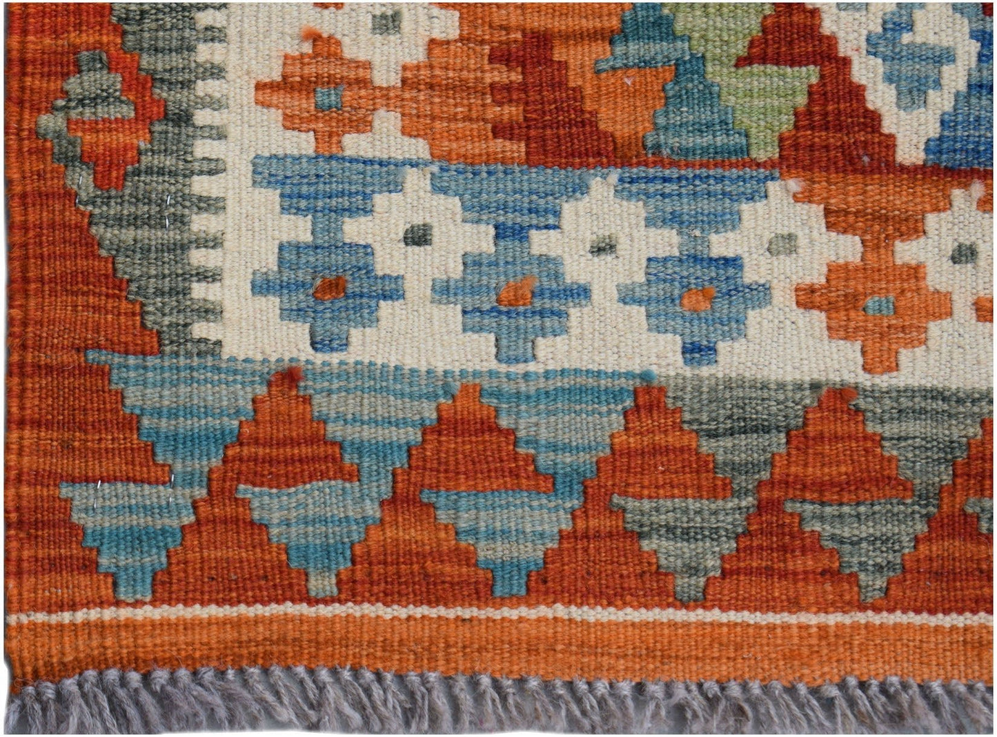 Handwoven Afghan Maimana wool runner featuring a geometric pattern in orange, blue, and grey.