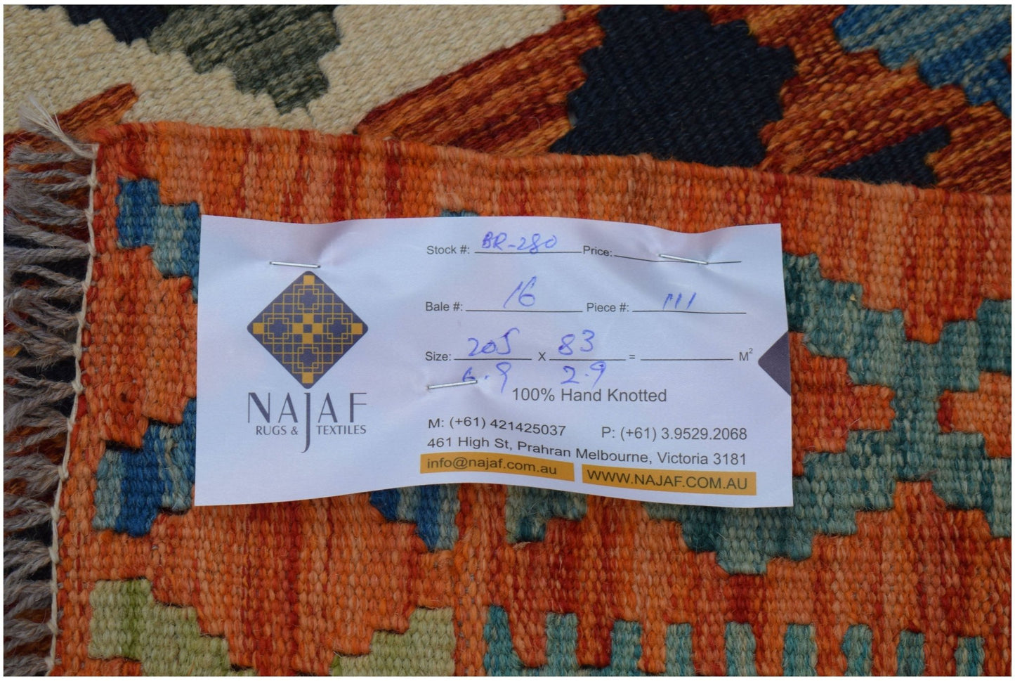 An Afghan Maimana kilim runner featuring a geometric pattern in orange, blue, and green tones.