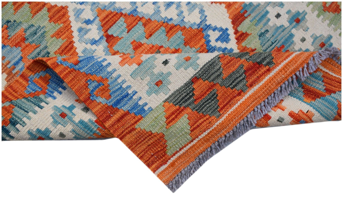 A handwoven Afghan Maimana kilim runner featuring a geometric pattern in orange, blue, and green.