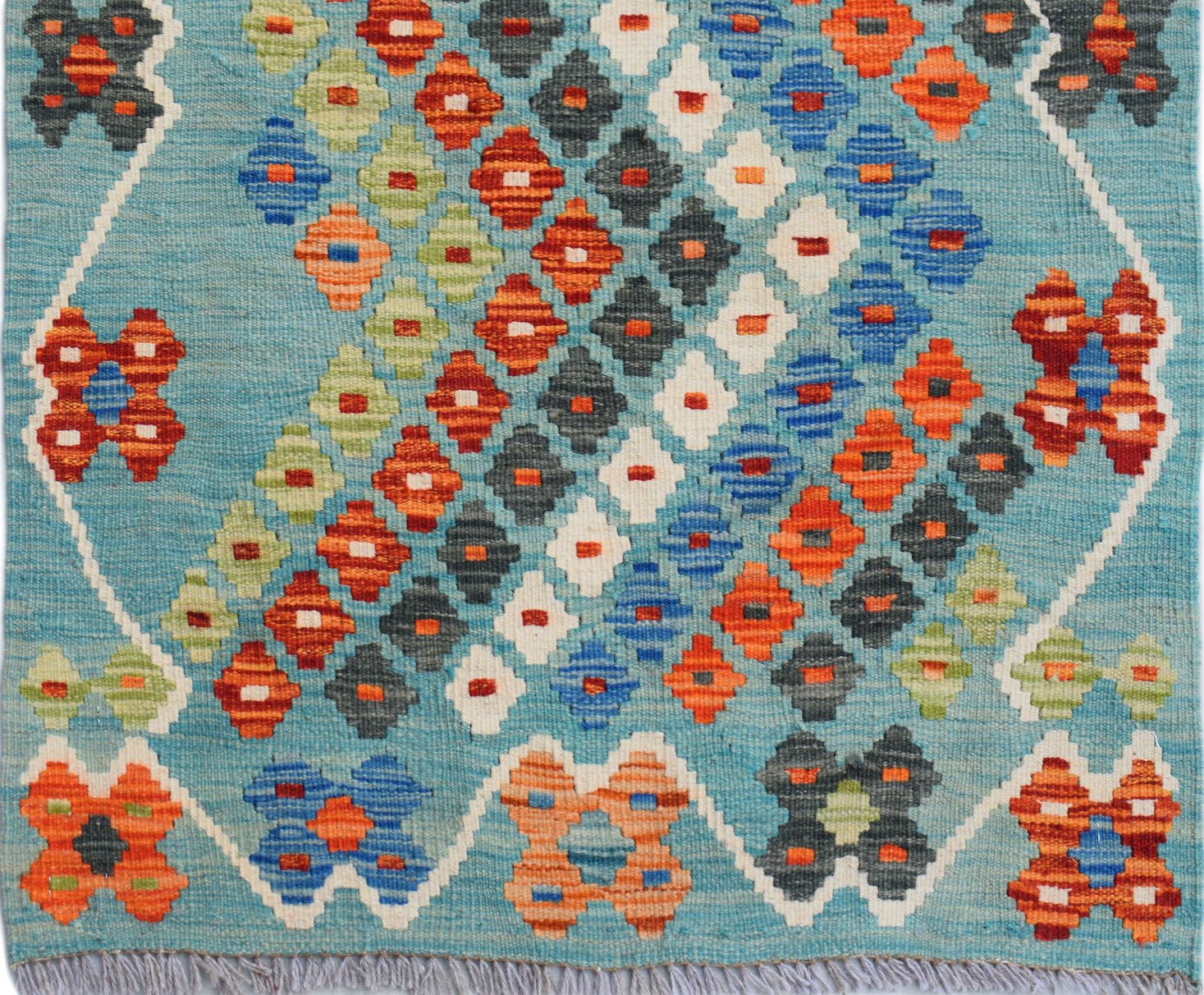 Handwoven Afghan Maimana wool runner featuring a geometric diamond pattern in vibrant colors.