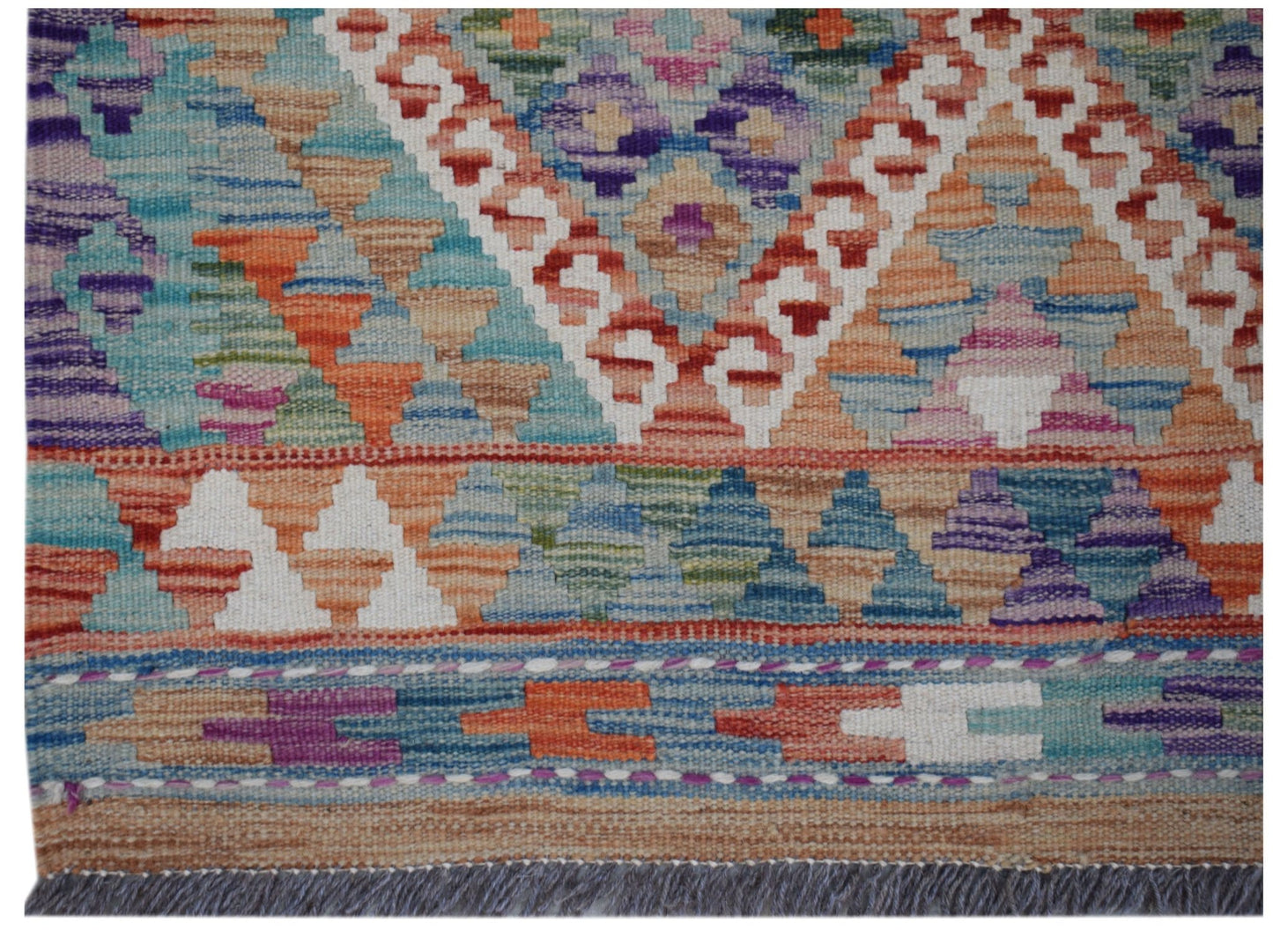 Handwoven Afghan Maimana wool runner featuring a colorful geometric pattern and fringed edges.