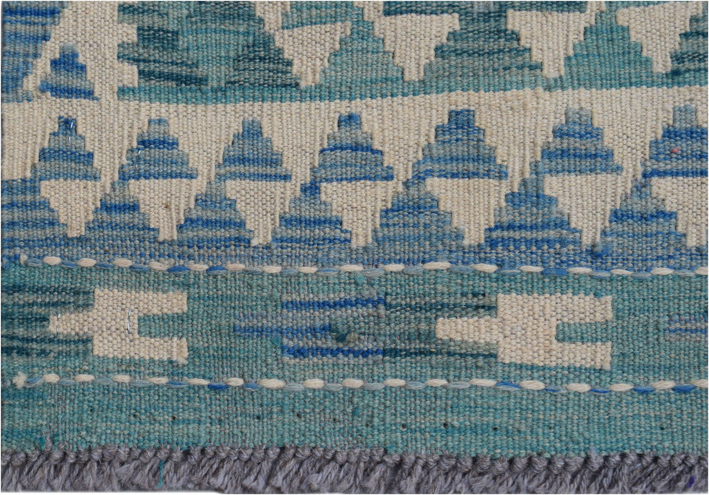 A handmade Afghan Maimana wool kilim runner featuring a geometric pattern in shades of blue.