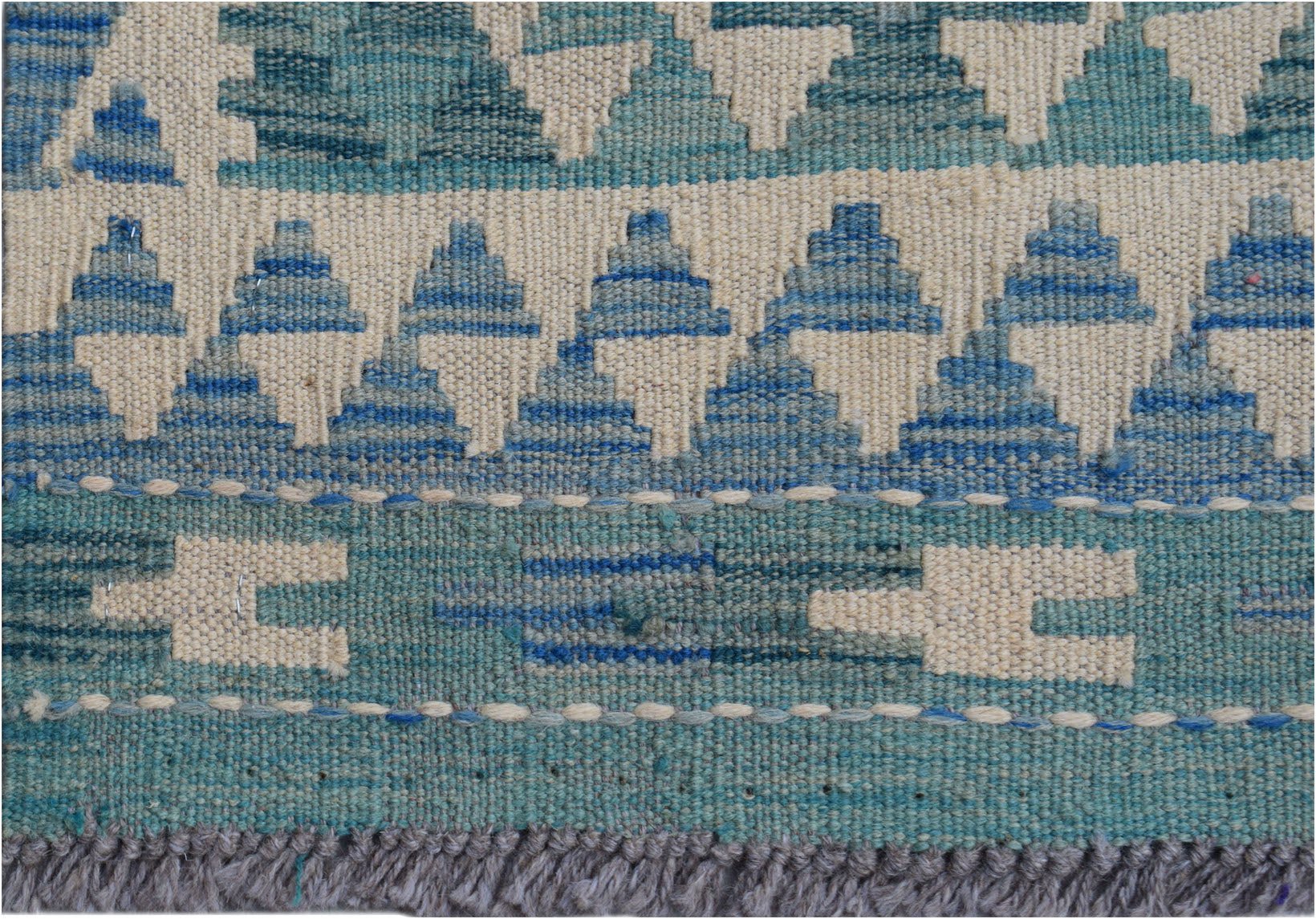A handmade Afghan Maimana wool kilim runner featuring a geometric pattern in shades of blue.