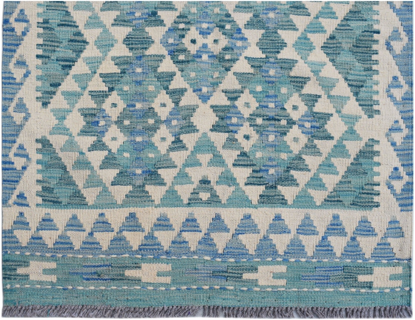 Handwoven Afghan Maimana wool runner featuring a geometric blue and cream diamond pattern.