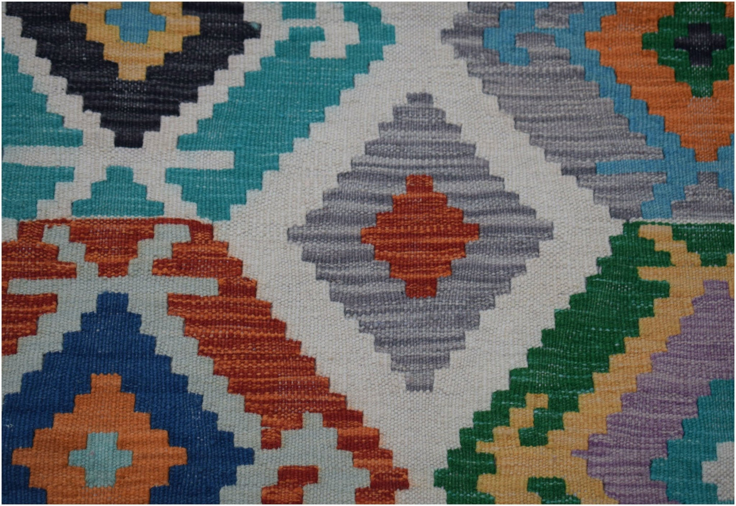 Handwoven Afghan Maimana kilim runner featuring a vibrant geometric pattern in wool.