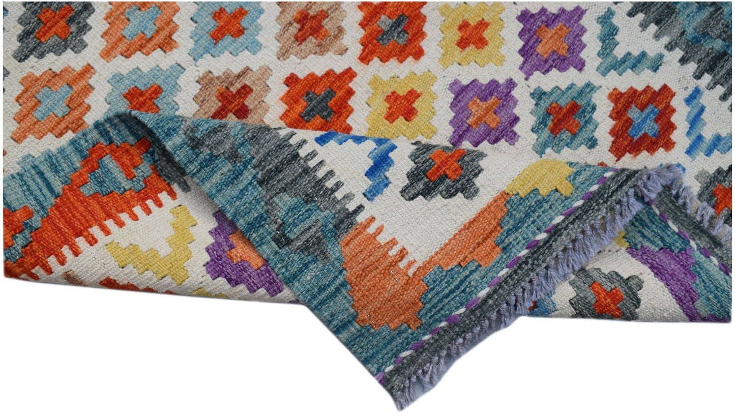 Handwoven Afghan Maimana wool runner featuring a colorful geometric pattern and fringed edges.