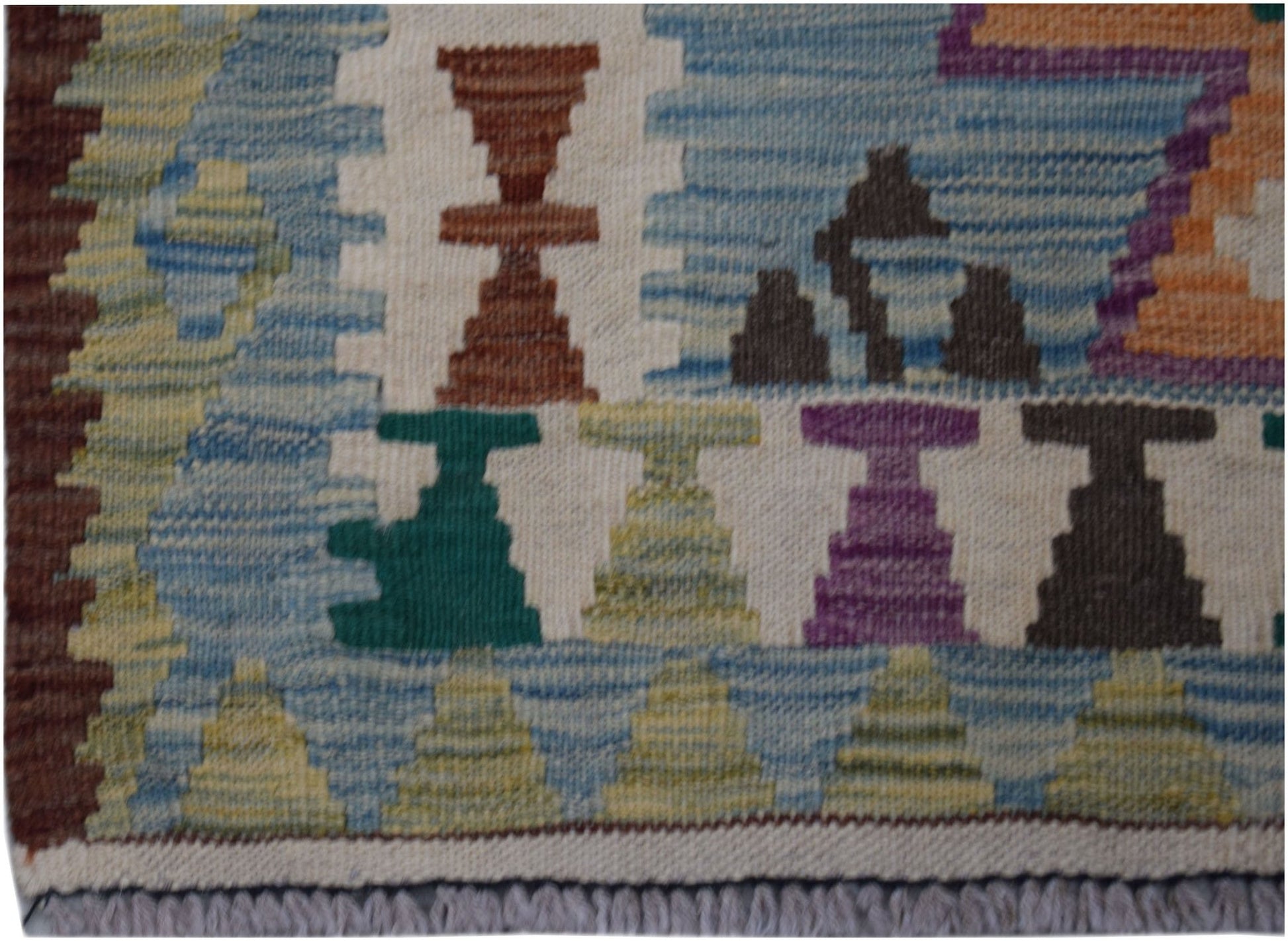 Handwoven Afghan Maimana wool runner featuring colorful geometric motifs on a cream background.