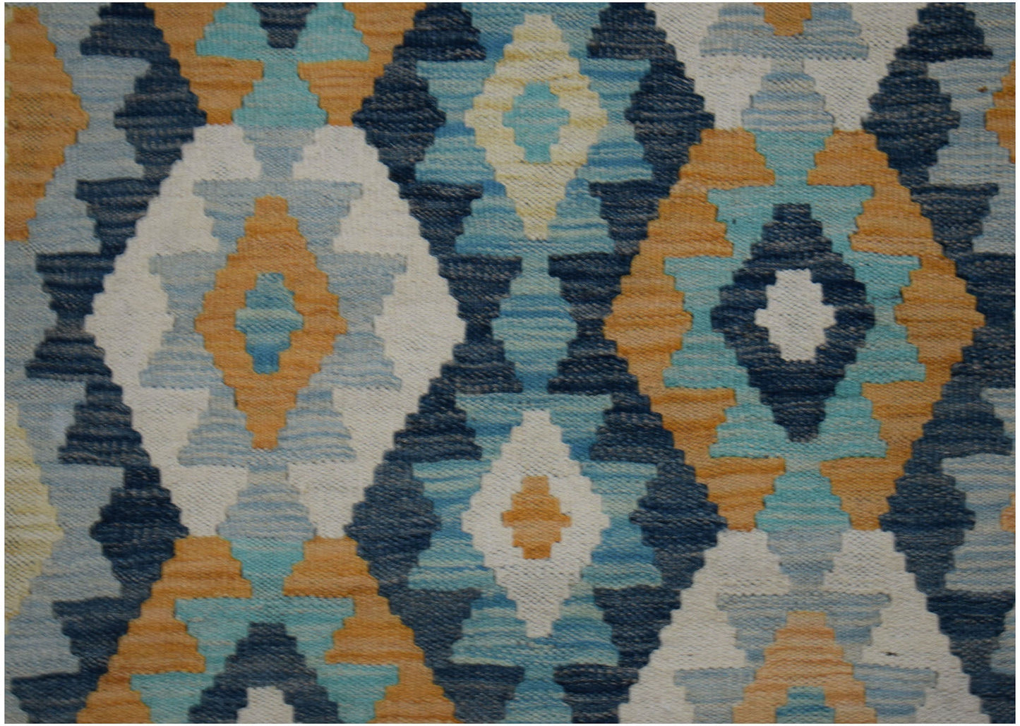 Handwoven wool runner featuring a geometric diamond pattern in shades of blue, orange, and cream.