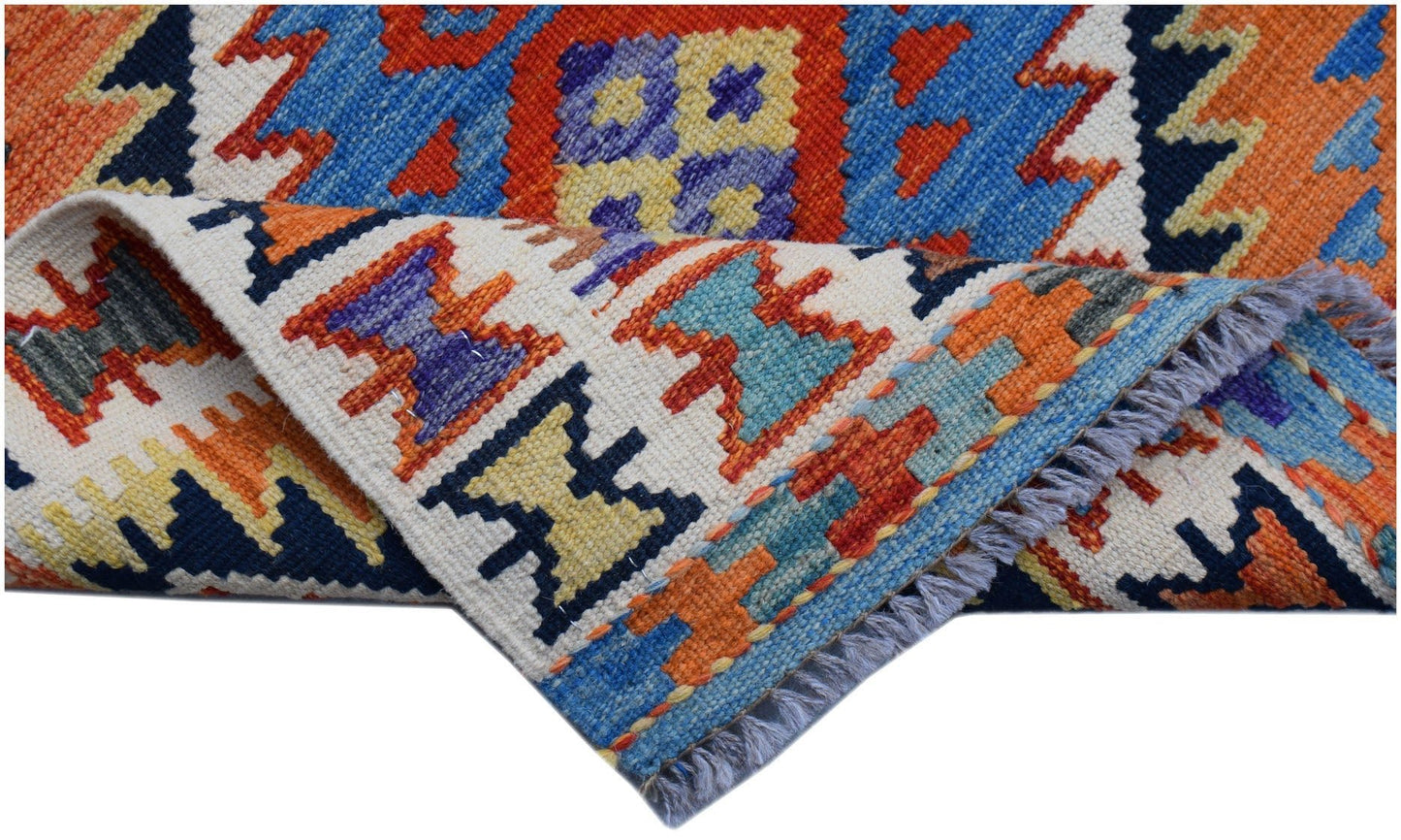 A handwoven Afghan Maimana wool kilim runner featuring vibrant geometric patterns and fringe.
