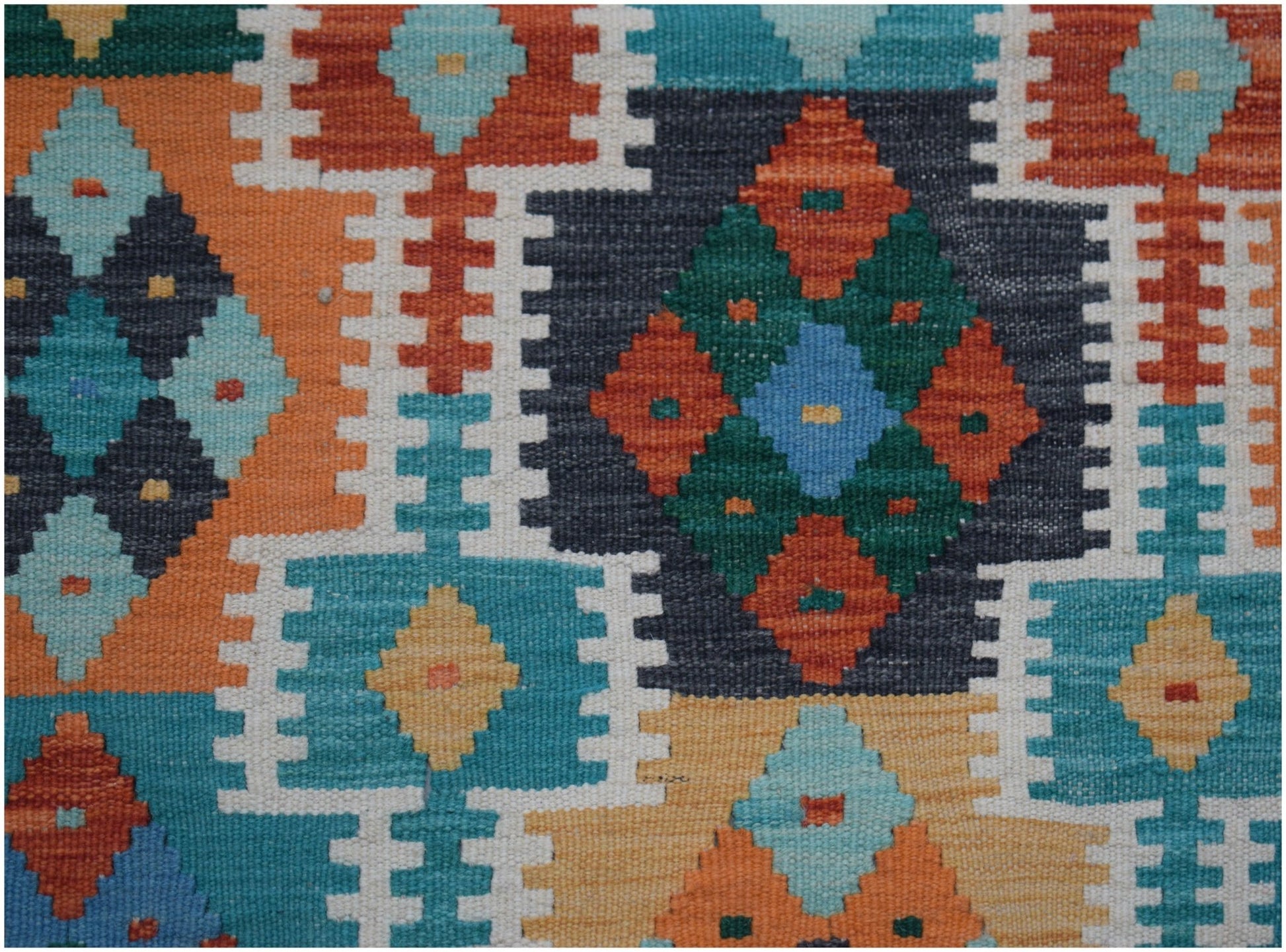 Handwoven Afghan Maimana kilim runner featuring a vibrant geometric pattern in wool.