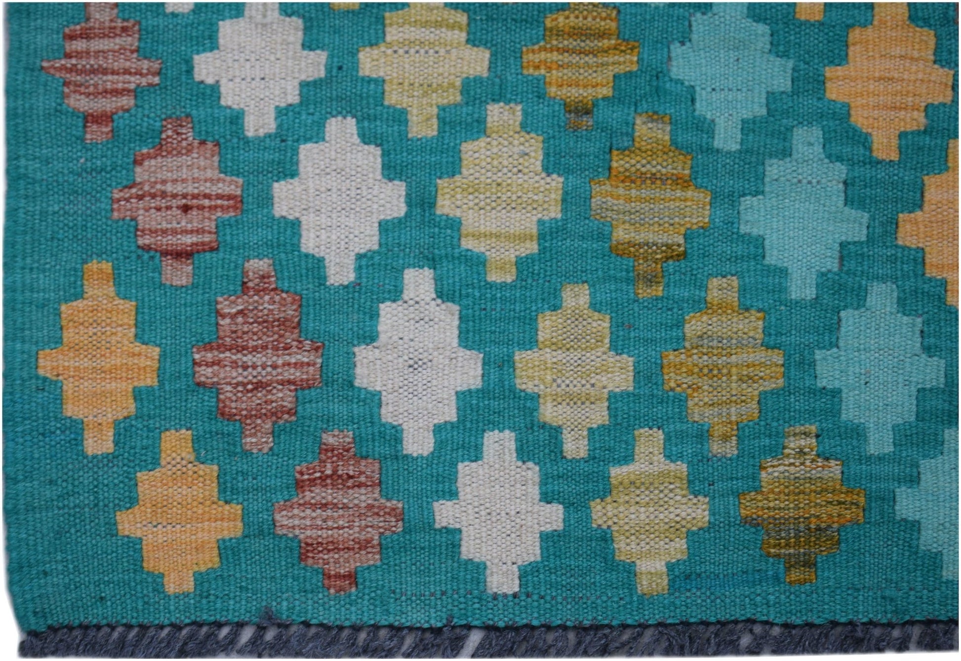 Handwoven Afghan Maimana kilim runner featuring a teal background with geometric multicolored shapes.