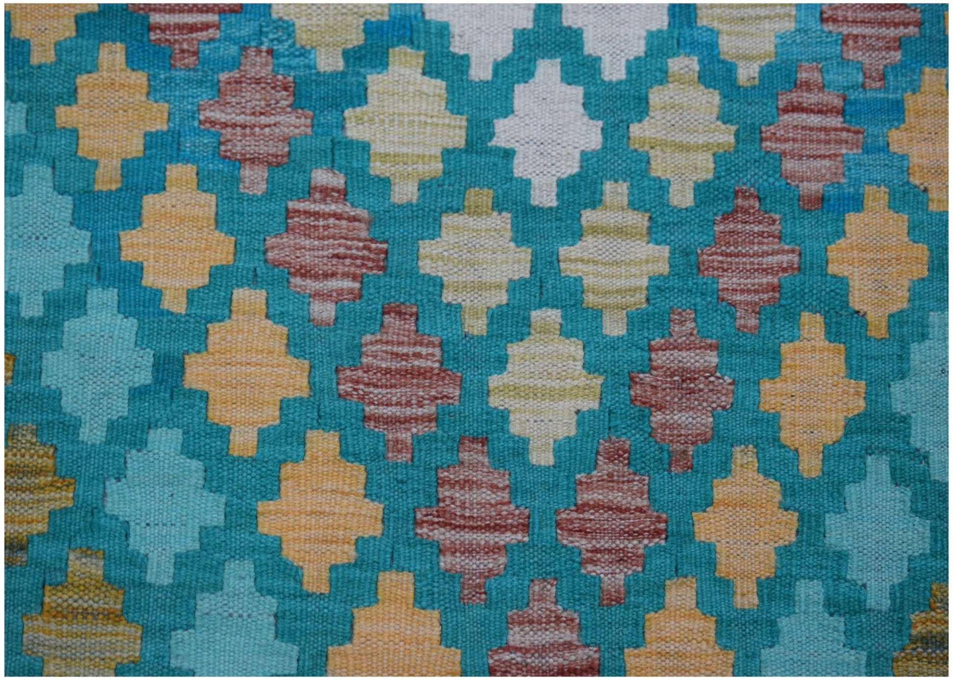 Handwoven Afghan Maimana kilim runner featuring a geometric pattern in teal, yellow, and red.
